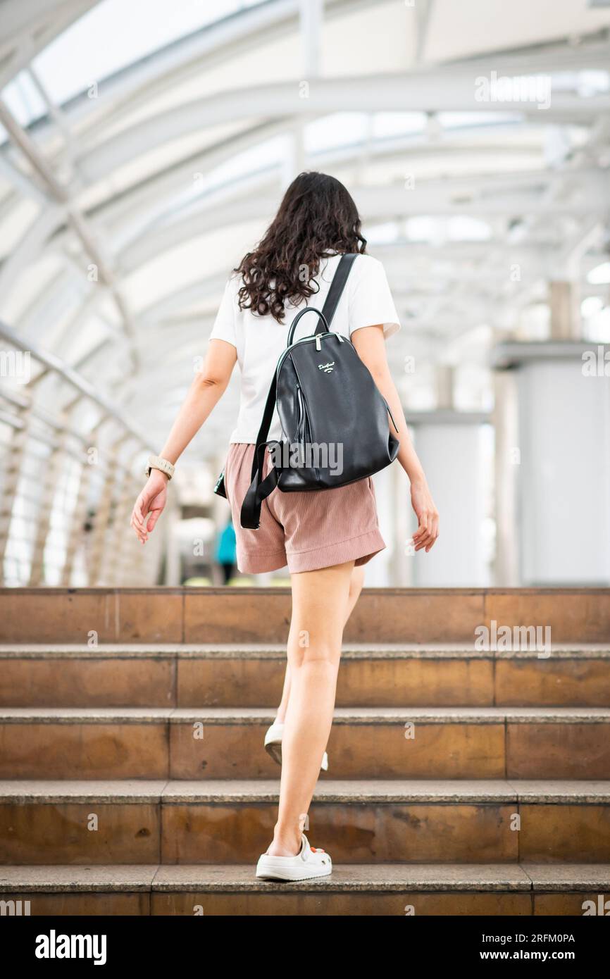 Une jeune fille thaïlandaise fait son chemin à travers la station de train aérien de Chong Nonsi BTS à Bangkok en Thaïlande. Banque D'Images