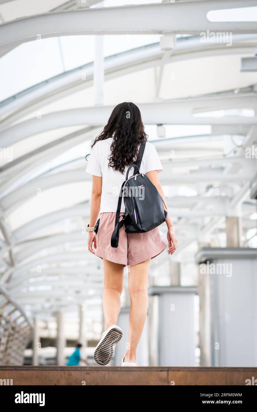 Une jeune fille thaïlandaise fait son chemin à travers la station de train aérien de Chong Nonsi BTS à Bangkok en Thaïlande. Banque D'Images