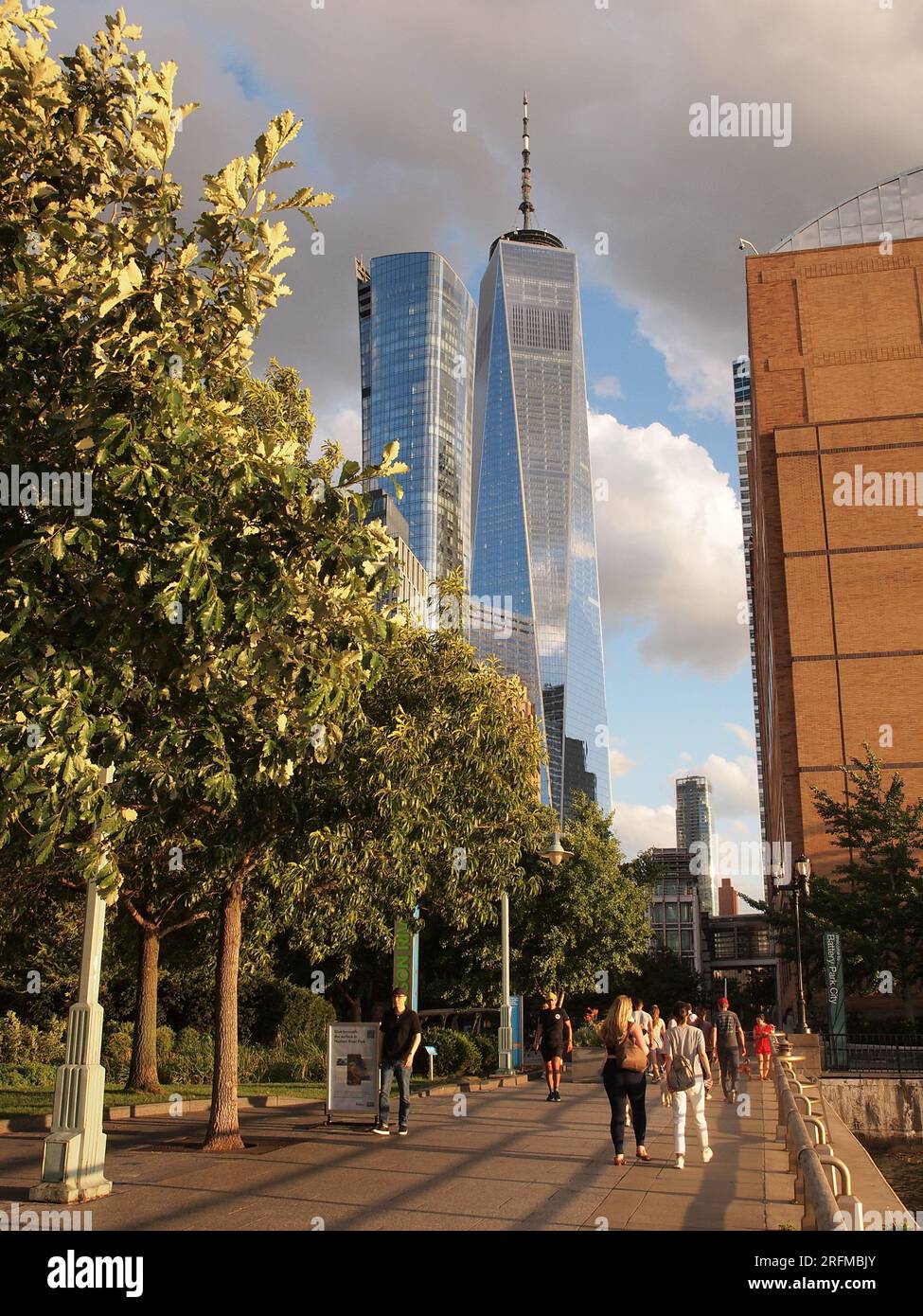 Tour de la liberté vue de West Street dans le Lower Manhattan, New York City avec des gens utilisant une promenade bordée d'arbres. Banque D'Images