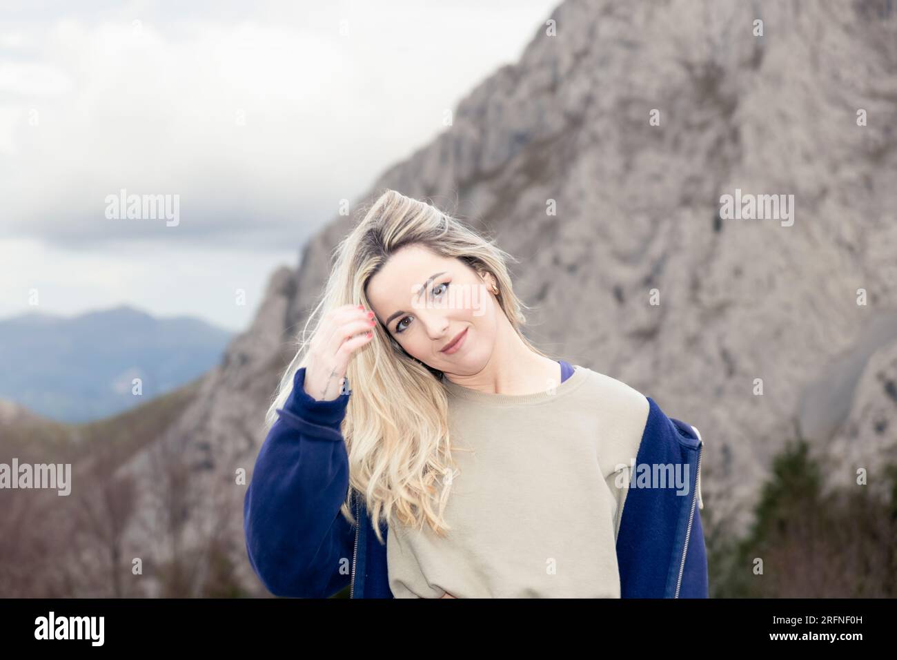 Touche tranquille de femme avec cheveux balayés par le vent au milieu d'un paysage de montagne Banque D'Images