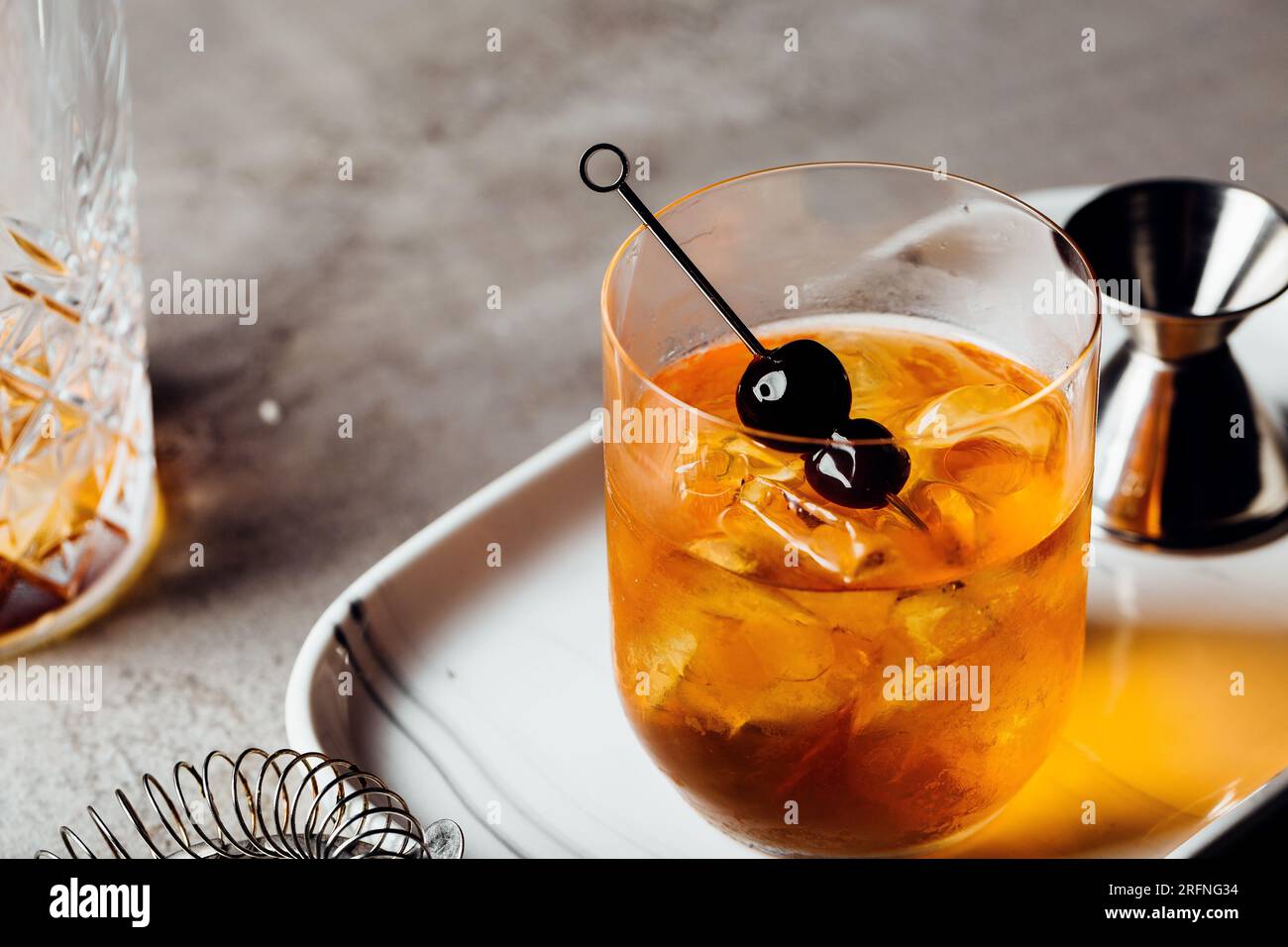 Alcool Manhattan boire sur les rochers Bourbon Whiskey et garnir de cerises Maraschino Banque D'Images