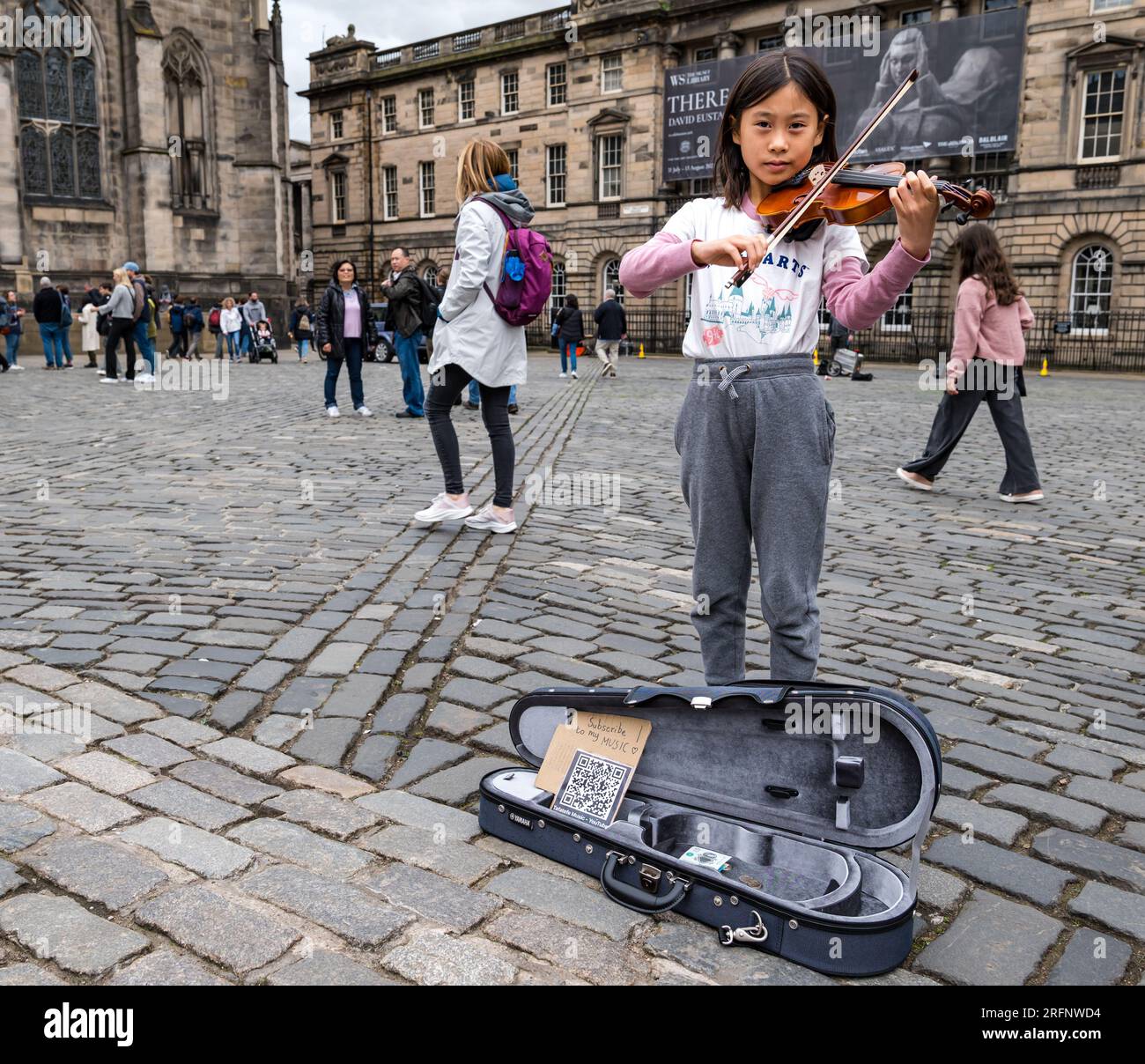 Édimbourg, Écosse, Royaume-Uni, 4 août 2023. Street perforrmers at Edinburgh Festival Fringe : le Fringe est réputé pour ses artistes de rue. Sur la photo : une jeune fille asiatique joue sur le Royal Mile des airs classiques au violon. Crédit : Sally Anderson/Alamy Live News Banque D'Images