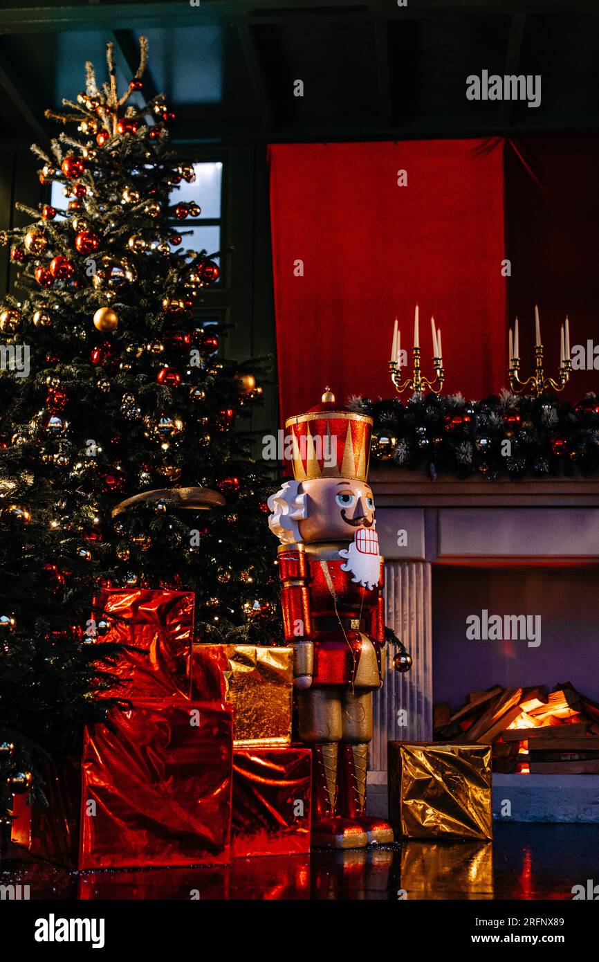 Sapin de Noël, bougies dorées, boîtes-cadeaux emballées et casse-noisette en bois dans les guirlandes lumineuses du soir. Décor festif, détails extérieurs du nouvel an hiver. VE Banque D'Images
