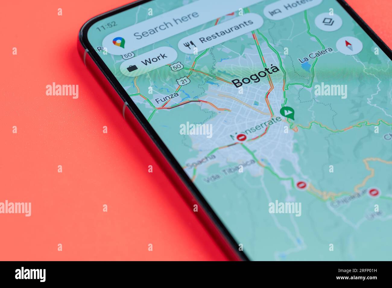 New York, USA - 21 juillet 2023 : carte des embouteillages à Bogota sur écran smartphone vue rapprochée avec fond rouge Banque D'Images
