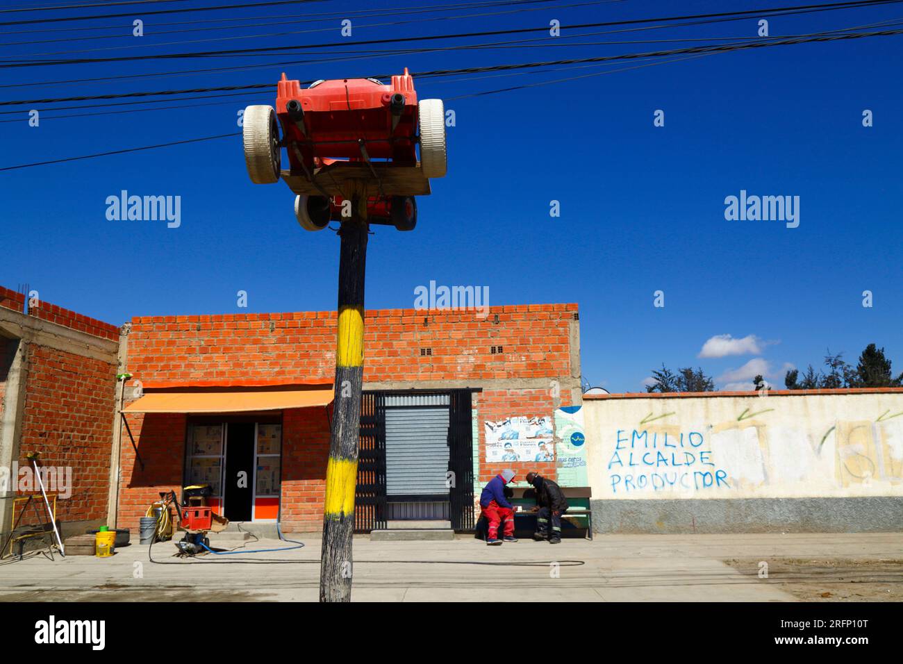 Grande voiture jouet en plastique sur poteau en bois peint en dehors de l'entreprise de lavage de voiture à côté de la route principale, El Alto, Bolivie Banque D'Images