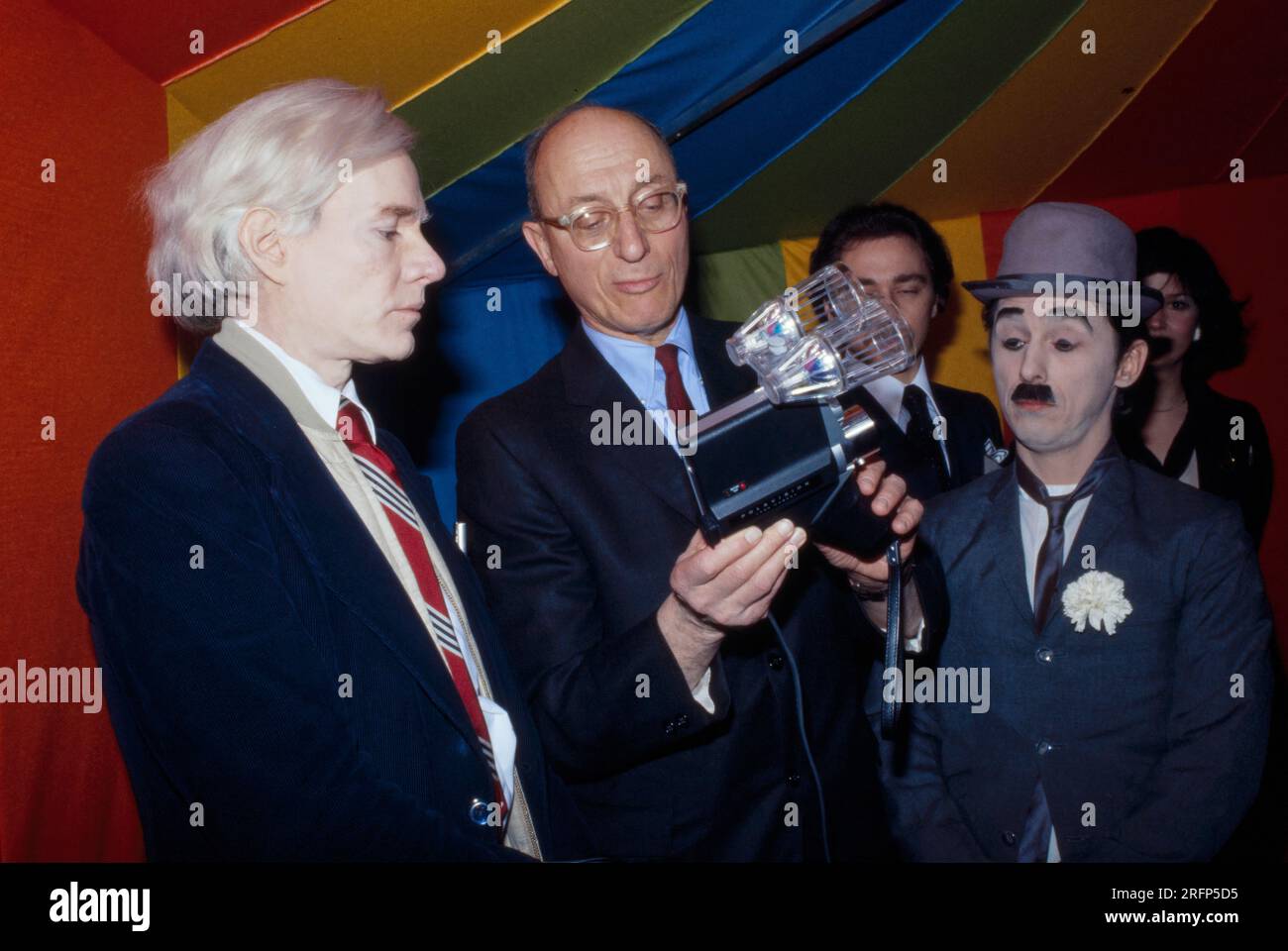 Andy Warhol avec la nouvelle caméra Polaroid Polavision lors d'une ouverture artistique en 1977. Warhol était un artiste visuel américain, réalisateur, producteur et figure de proue du mouvement pop art. Ses œuvres explorent la relation entre l'expression artistique, la publicité et la culture des célébrités qui a prospéré dans les années 1960, et couvrent une variété de médias, y compris la peinture, la sérigraphie, la photographie, le cinéma, et sculpture. Parmi ses œuvres les plus connues figurent les peintures sérigraphiées Campbell's Soup Cans et Marilyn diptyque. Photo de Bernard Gotfryd Banque D'Images