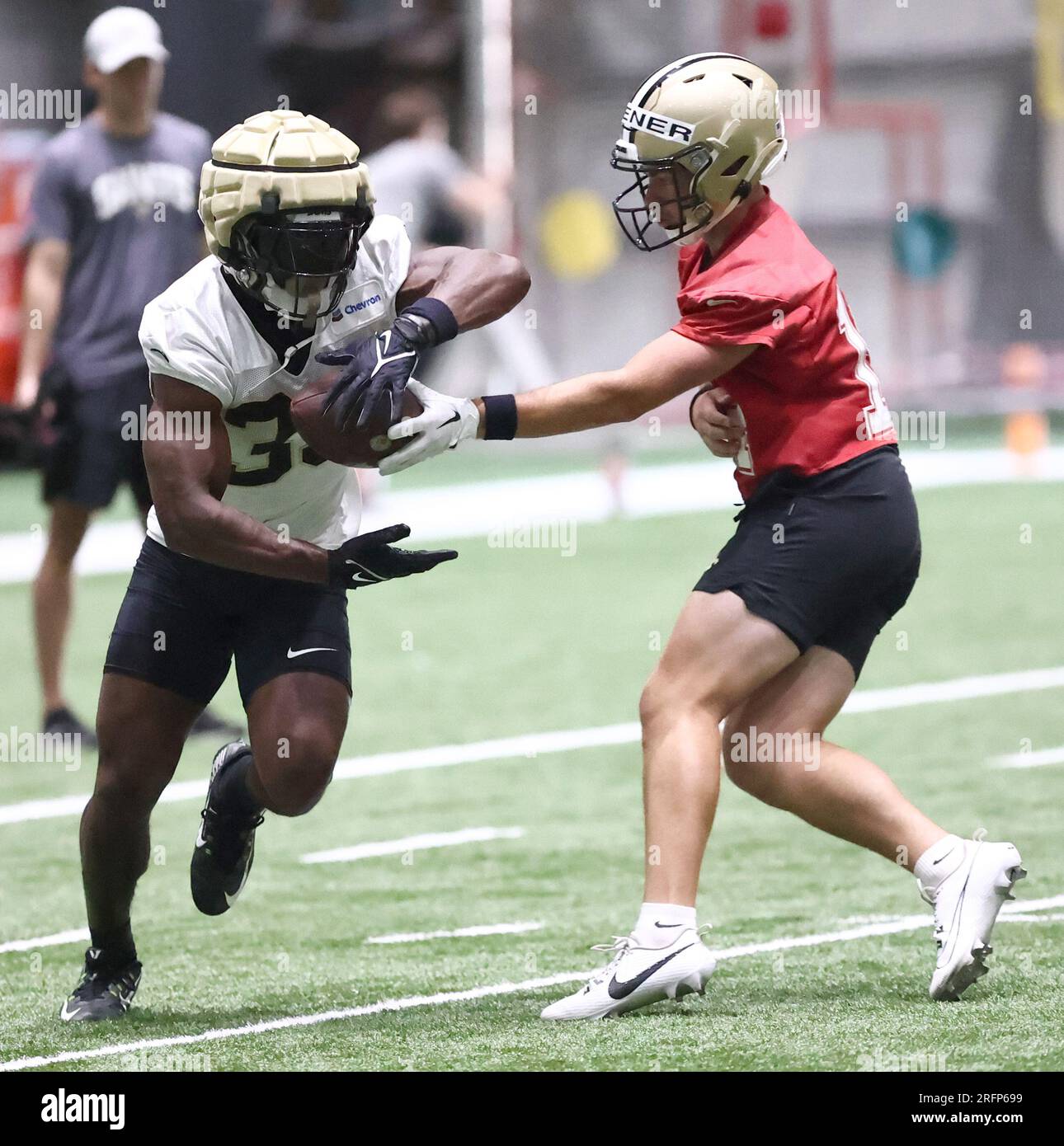 Metairie, États-Unis. 04 août 2023. Le quarterback Jake Haener (14 ans) remet le ballon au running back Kirk Merritt (33 ans) pendant le camp d'entraînement des Saints de la Nouvelle-Orléans à l'Ochsner Sports Performance Center Indoor Facility à Metairie, Louisiane, le vendredi 4 août 2023. (Photo de Peter G. Forest/Sipa USA) crédit : SIPA USA/Alamy Live News Banque D'Images