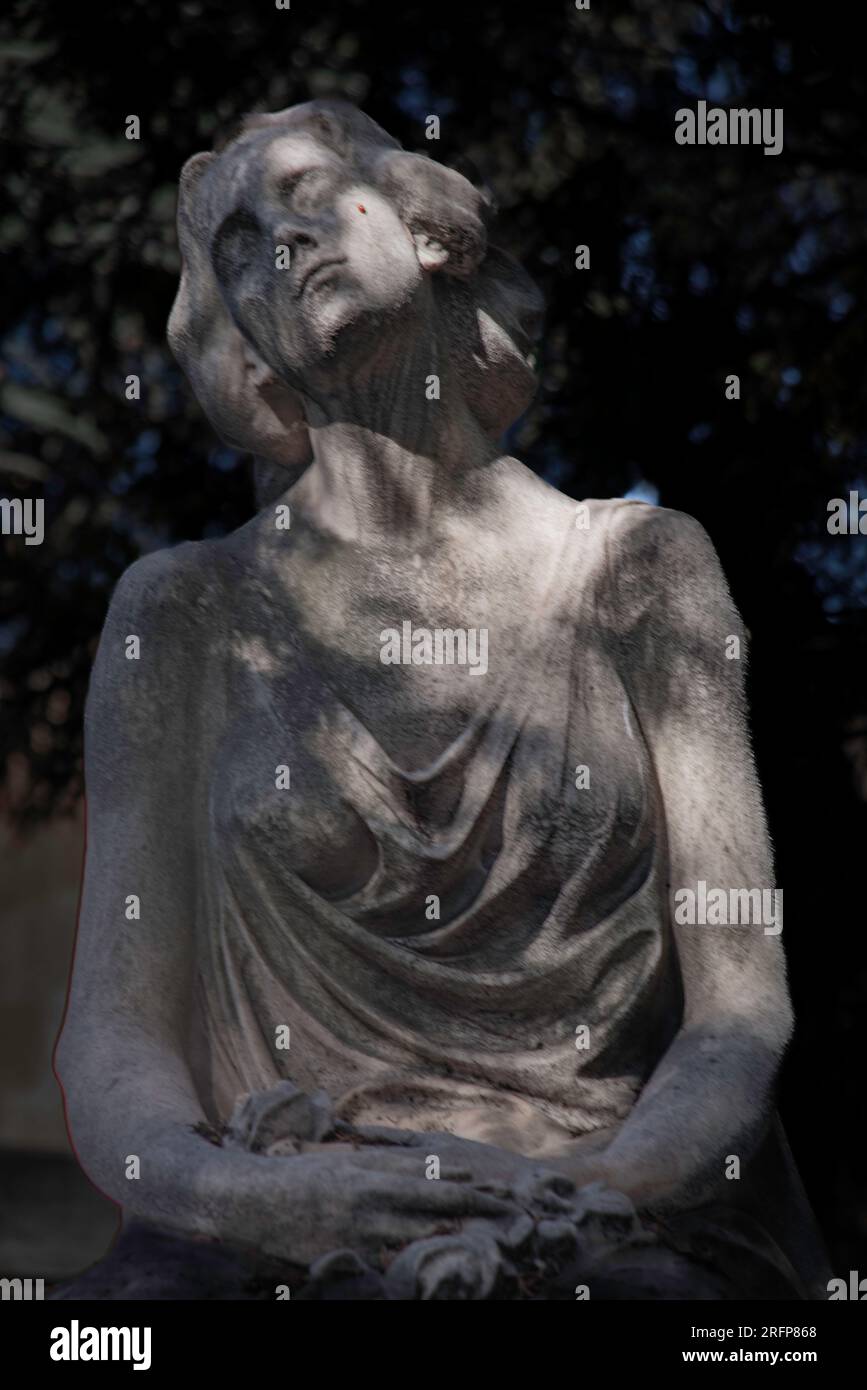 Statue de cimetière regardant vers le haut avec les yeux fermés avec la lumière frappant sa joue Banque D'Images