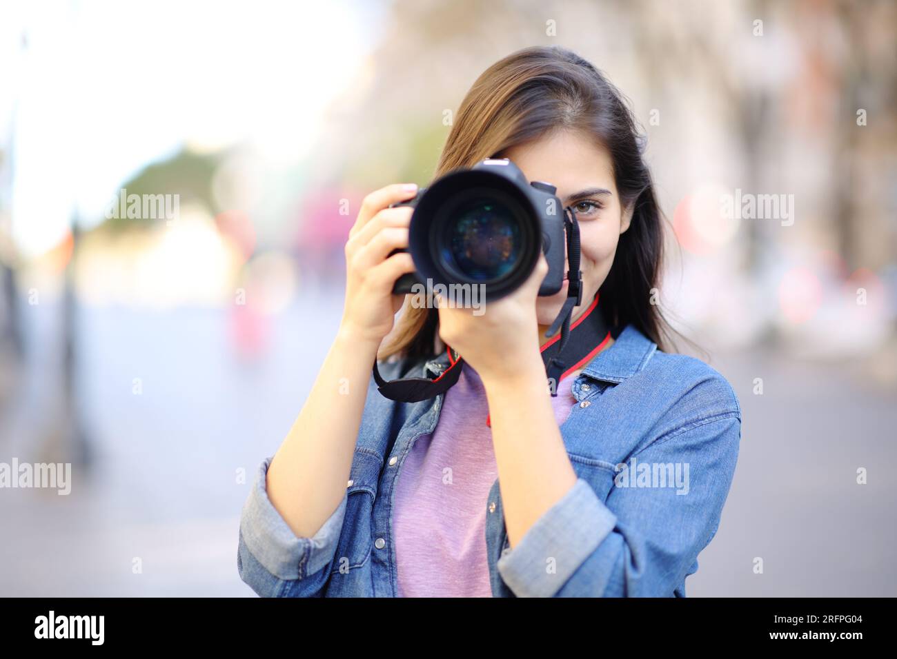 Photographe prenant des photos de vous avec un reflex numérique dans la rue Banque D'Images