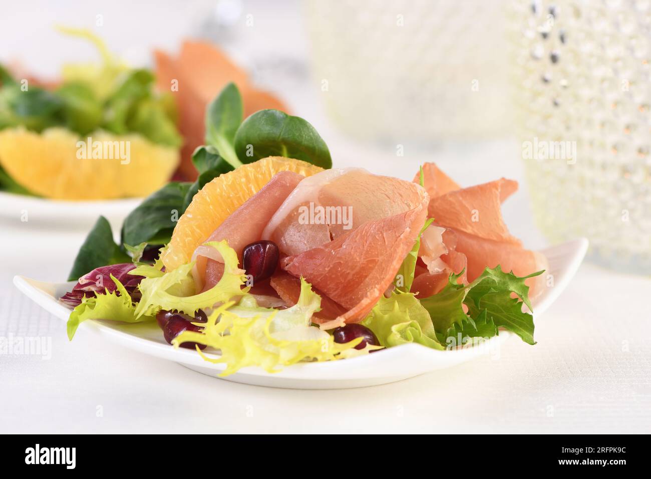 Apéritif au jambon de prosciutto servi sur un de mélangé à de l'orange et de la grenade. Banque D'Images