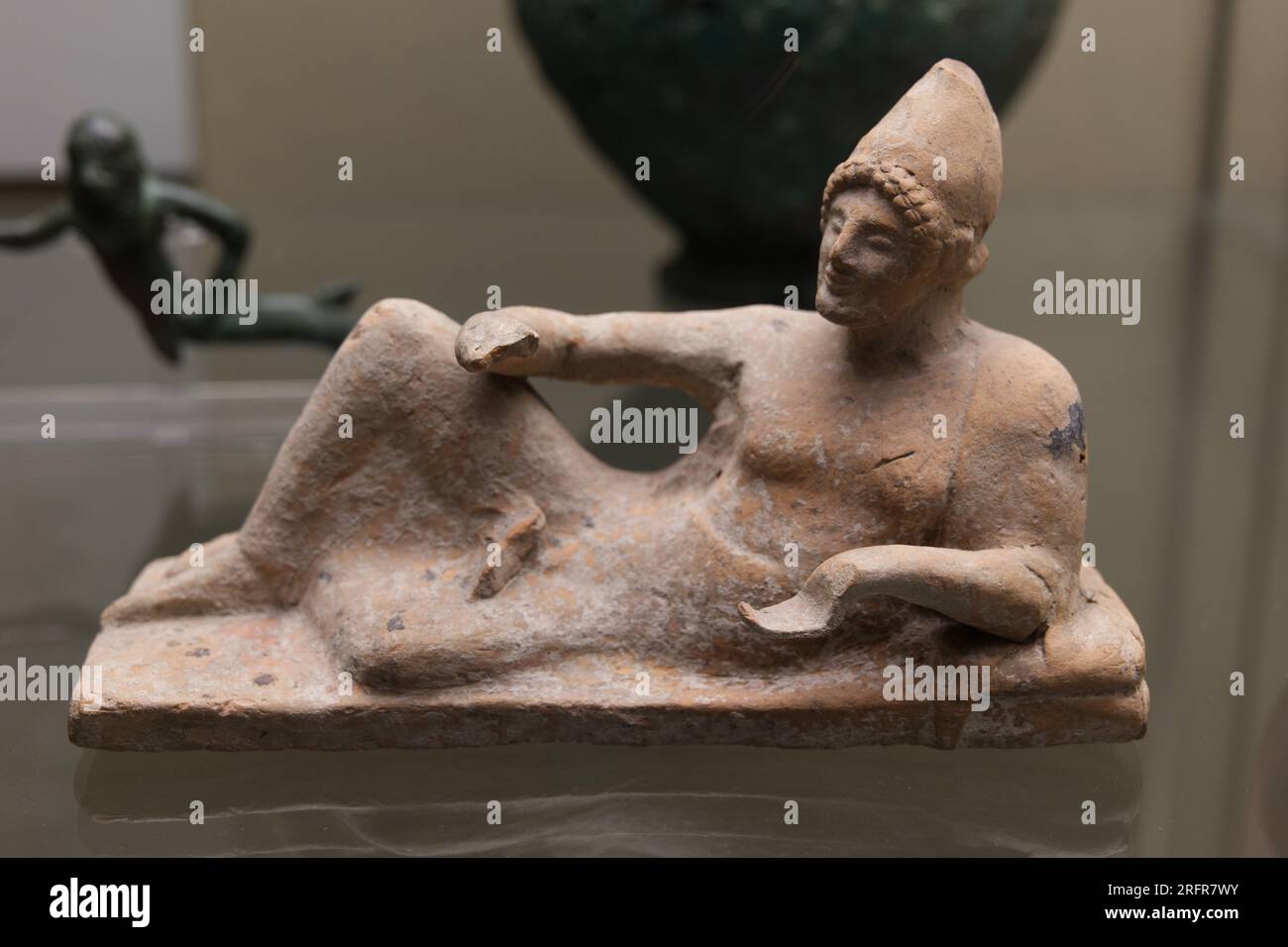 Figure en terre cuite d'un homme couché à un festin portant un chapeau pointu de type oriental. Fabriqué dans le Troad, environ 500 av. J.-C. de Troy, Turquie Banque D'Images