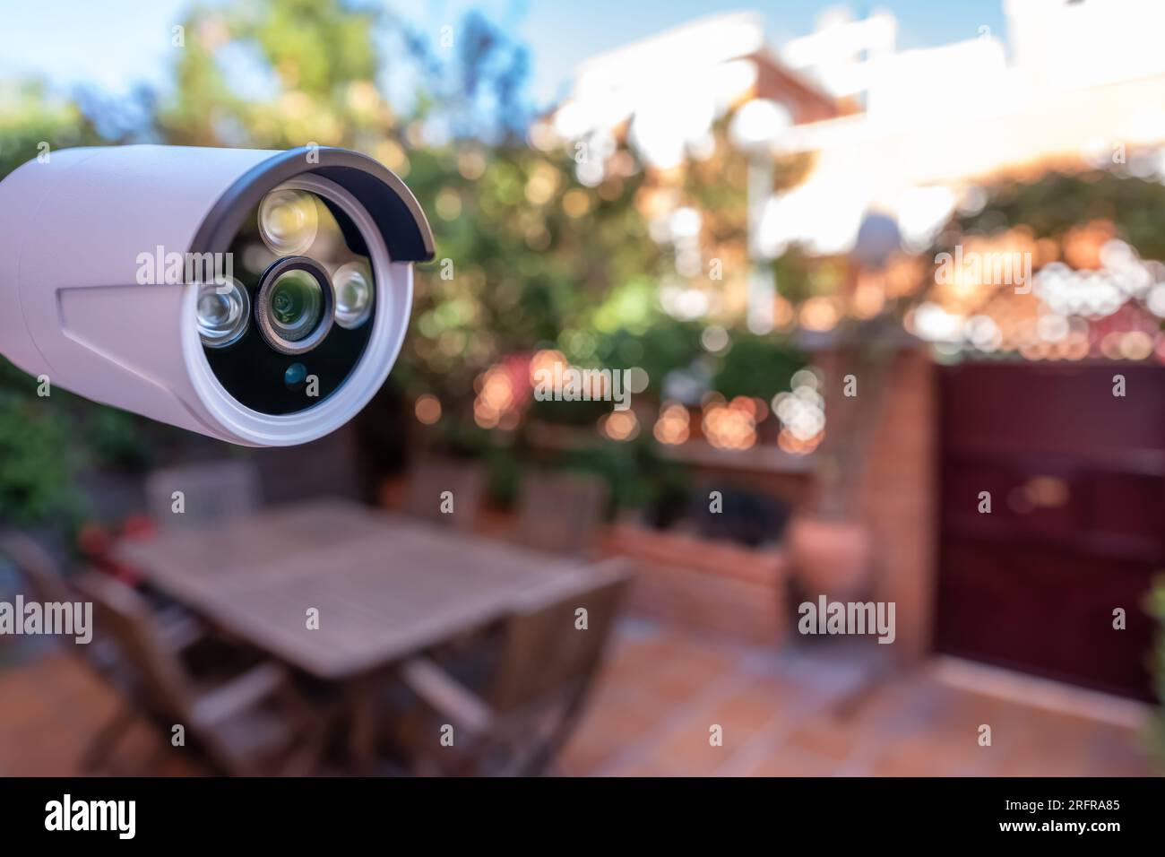 Caméra de sécurité installée dans le jardin d'une maison pour la  surveillance de la porte d'entrée de la maison Photo Stock - Alamy