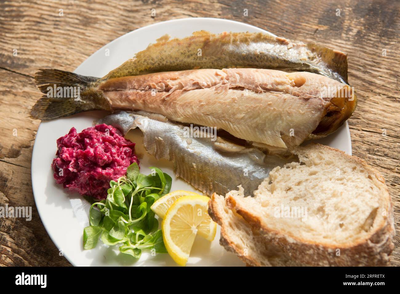 Truite arc-en-ciel fumée chaude, Oncoryhnchus mykiss, servie avec une sauce au raifort et à la betterave, une salade de laitue d’agneau et des tranches de citron. Angleterre Royaume-Uni GB Banque D'Images