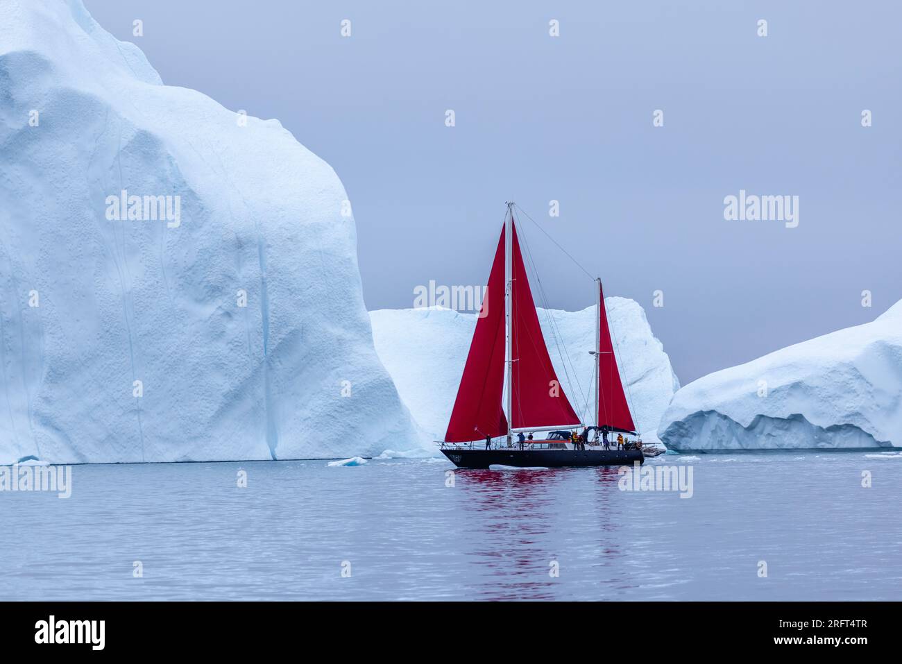 Des voiles rouges longent le fjord de glace d'Ilulissat au nord du cercle polaire arctique, dans la baie de Disko, au Groenland Banque D'Images