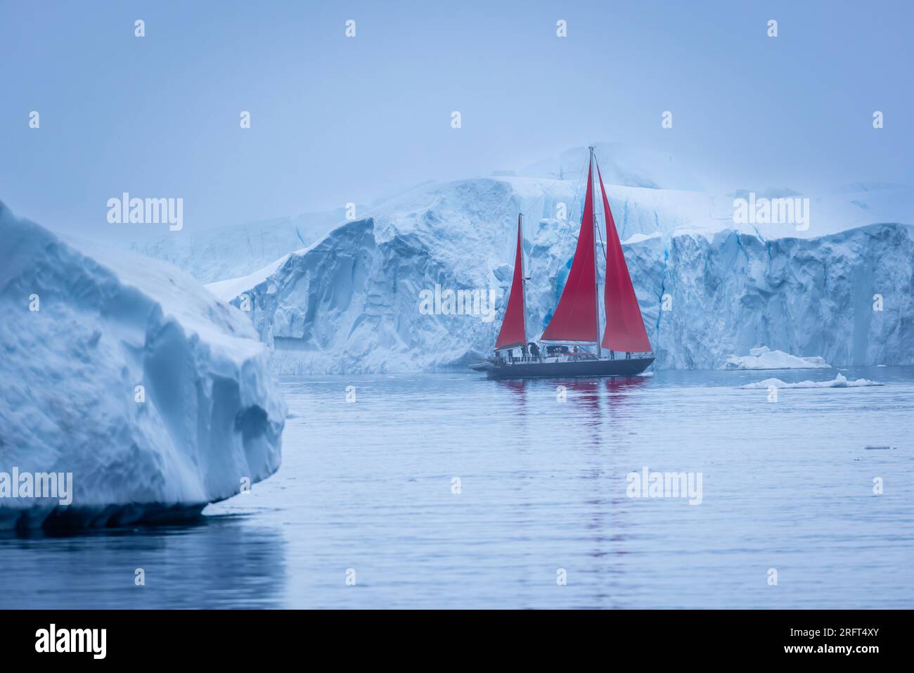 Des voiles rouges longent le fjord de glace d'Ilulissat au nord du cercle polaire arctique, dans la baie de Disko, au Groenland Banque D'Images