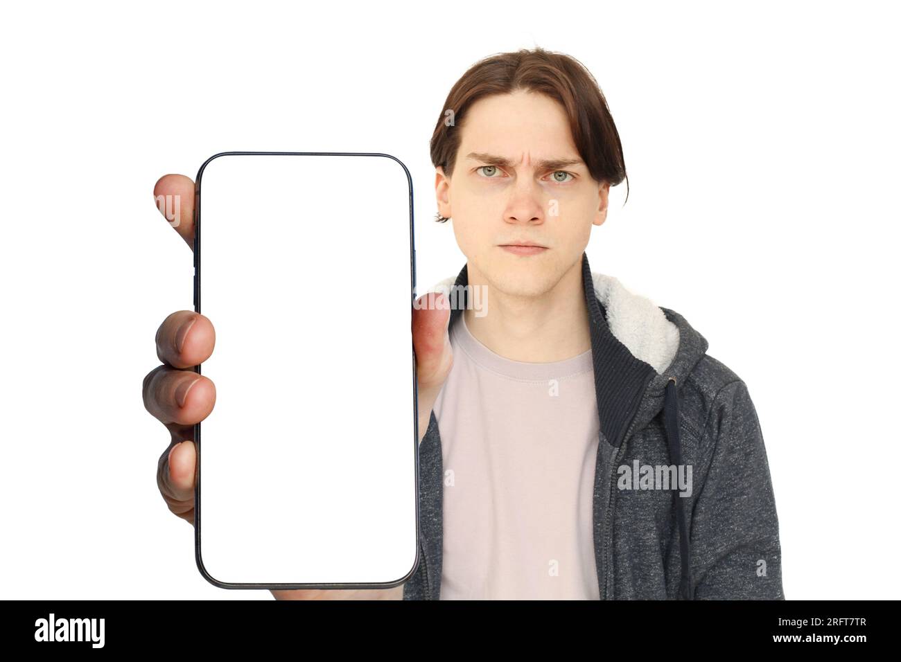 Smartphone avec écran blanc vide dans la main de jeune homme sérieux isolé sur fond blanc Banque D'Images