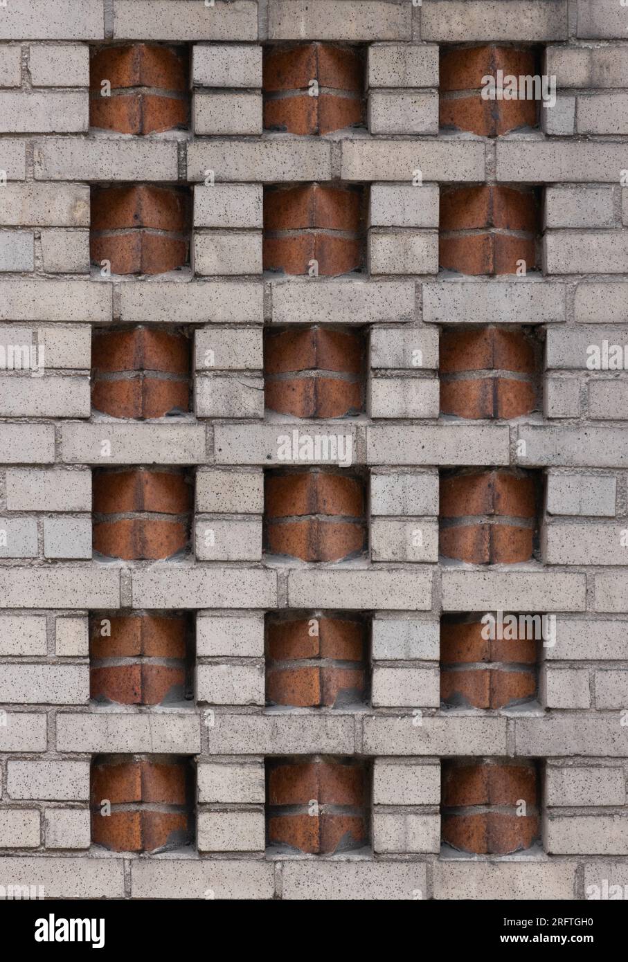 motif de brique décorative art déco à deux tons dans un mur de briques beiges avec des inserts de briques de couleur terre cuite dans un placement en dents de scie créent une géométrie Banque D'Images