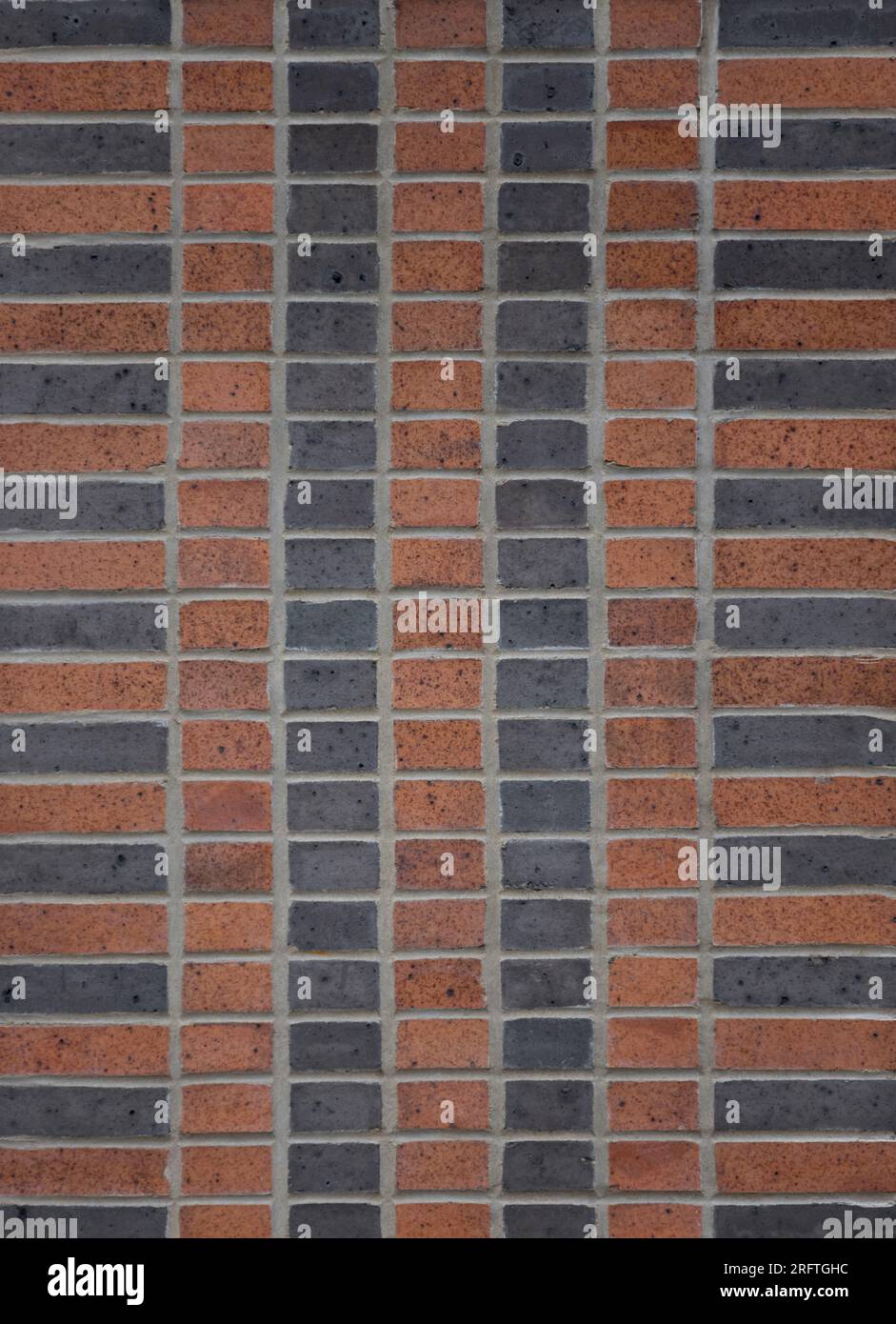 mur de briques de deux tons en terre cuite et noir, modèle de liaison d'empilement avec quatre rangées verticales de demi-briques au centre et une rangée verticale de brancard Banque D'Images