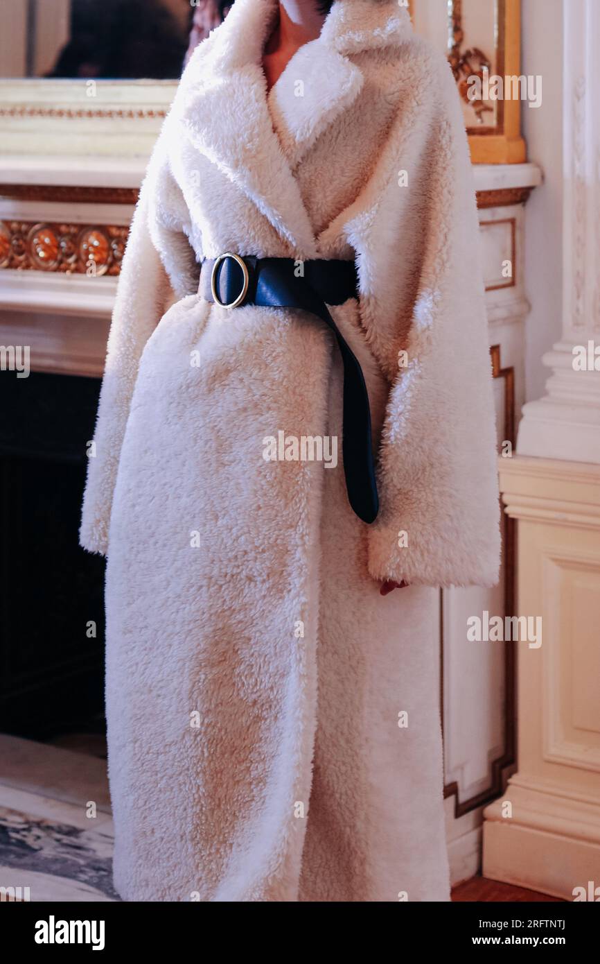 Détails de mode de long manteau chaud blanc avec ceinture noire. Tenue tendance, concept de vêtements féminins automne hiver. Banque D'Images