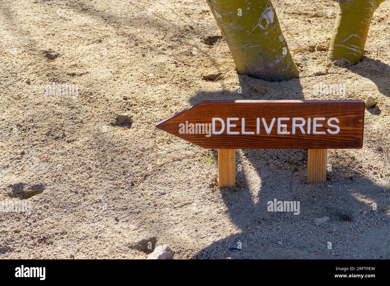Panneau de livraison en bois avec flèche dans le sol. La flèche pointe vers la gauche. Espace pour copier l'espace. Banque D'Images