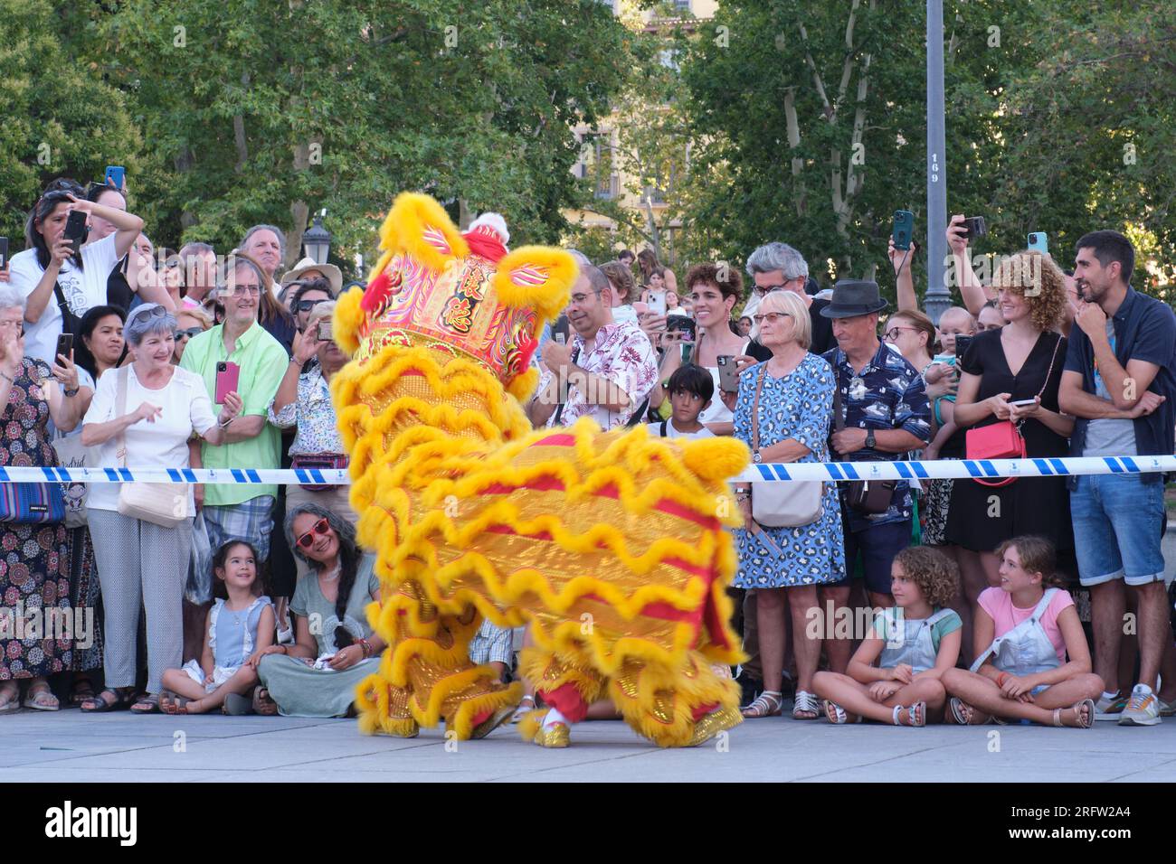 Madrid, Espagne. 5 août 2023. Les gens regardent danser le lion sur la Plaza de Oriente (place de l’est) à Madrid, en Espagne, le 5 août 2023. La troupe de danse du Lion Shenzhen Fuyong Huaide s'est produite dans les rues de Madrid du vendredi au dimanche à l'invitation du Festival de Madrid l'été dans la ville et du Centre culturel chinois de Madrid. Crédit : Meng Dingbo/Xinhua/Alamy Live News Banque D'Images