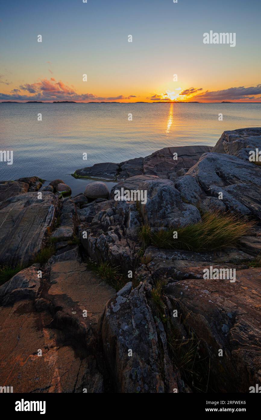 Belle vue sur la côte rocheuse et la falaise et la mer Baltique à Hanko, en Finlande, au coucher du soleil en été. Banque D'Images