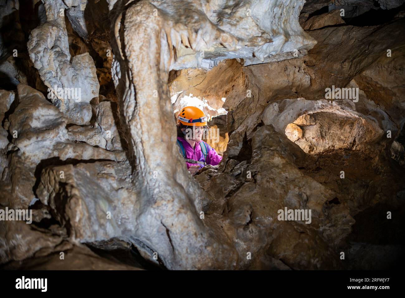 Jeune femme spelunking à l'intérieur d'une grotte. Concept féministe. Concept de sport féminin. Banque D'Images