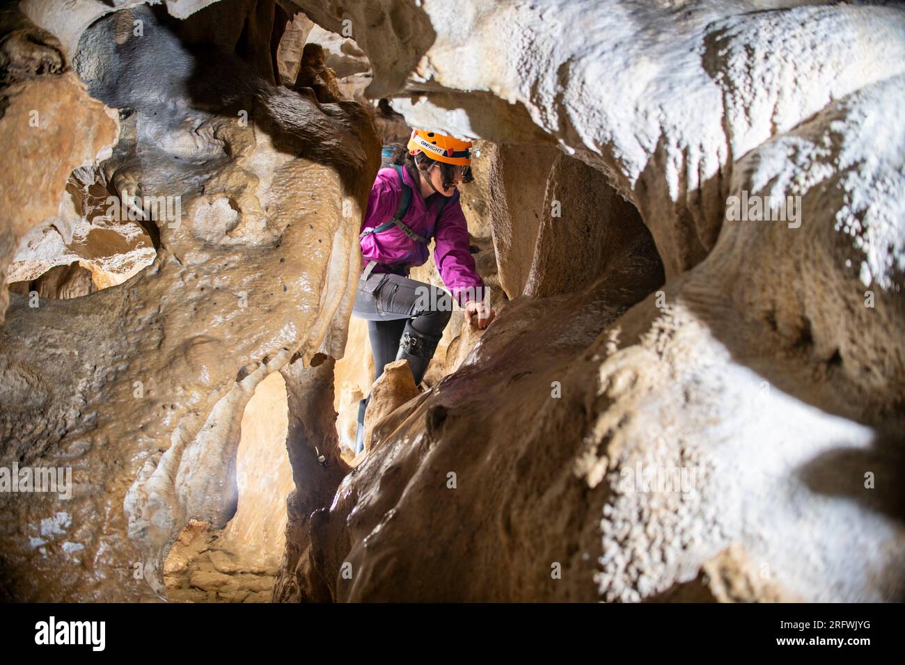 Jeune femme spelunking à l'intérieur d'une grotte. Concept féministe. Concept de sport féminin. Banque D'Images
