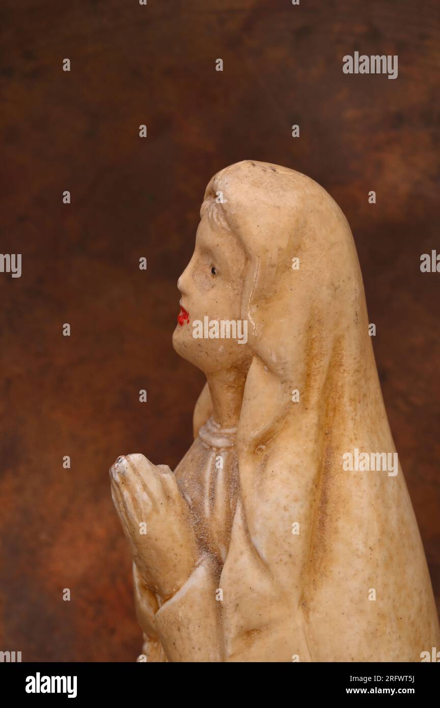 Modèle de femme peut-être une nonne ou la Vierge Marie regardant vers le ciel avec les mains ensemble dans la prière Banque D'Images