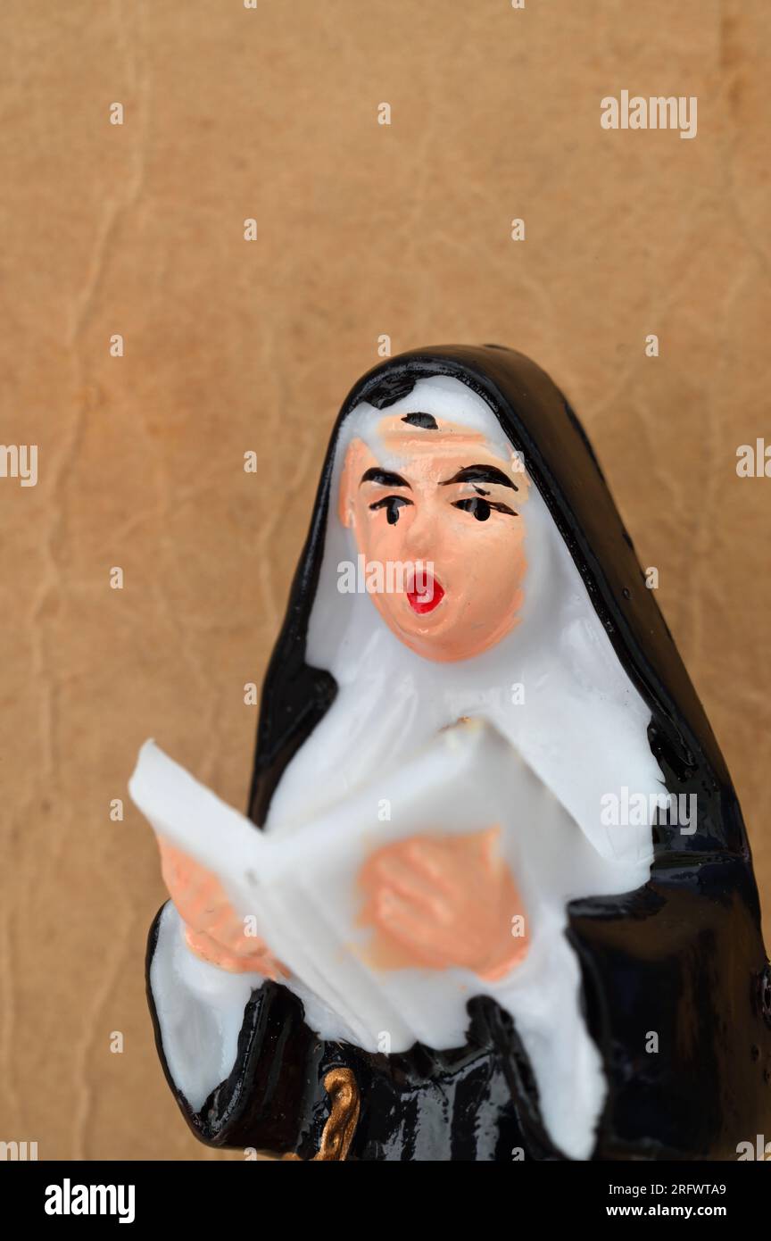 Modèle de nonne en bvlack et chant blanc du livre d'hymne tenu en altitude Banque D'Images