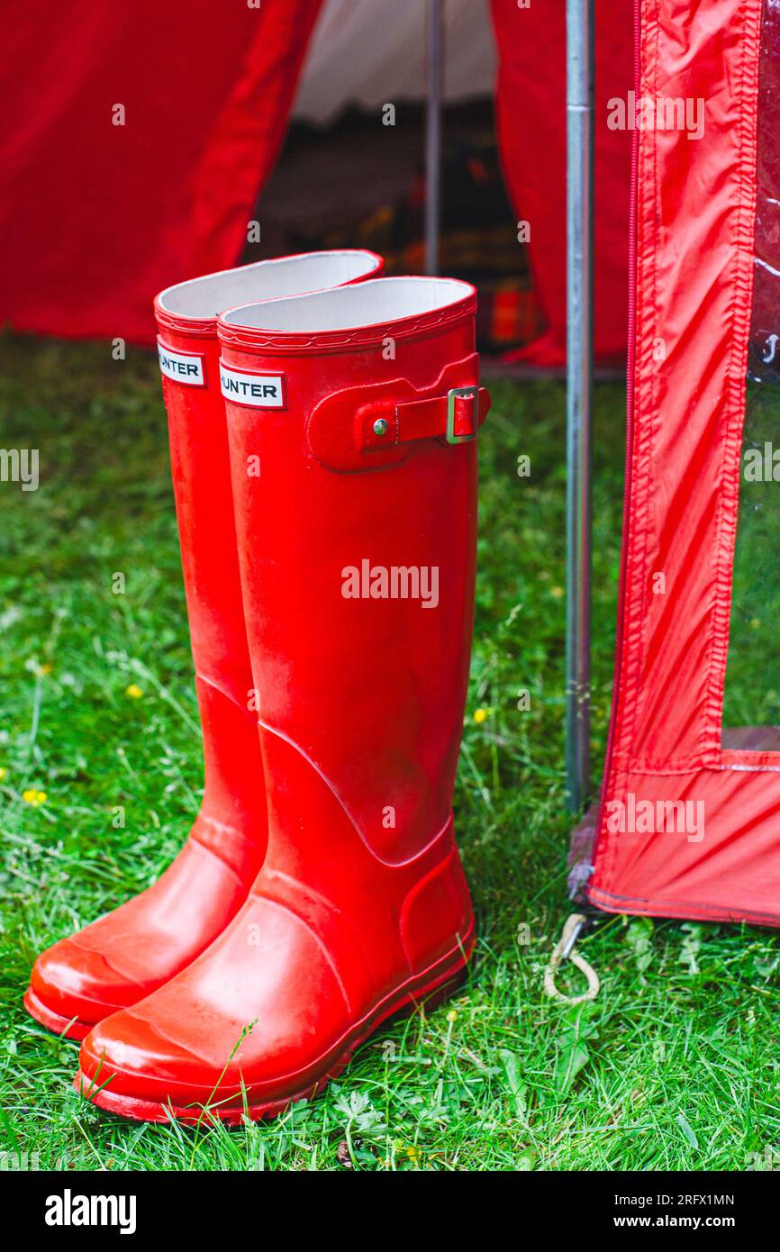 paire de bottes de pluie rouges devant la tente Banque D'Images