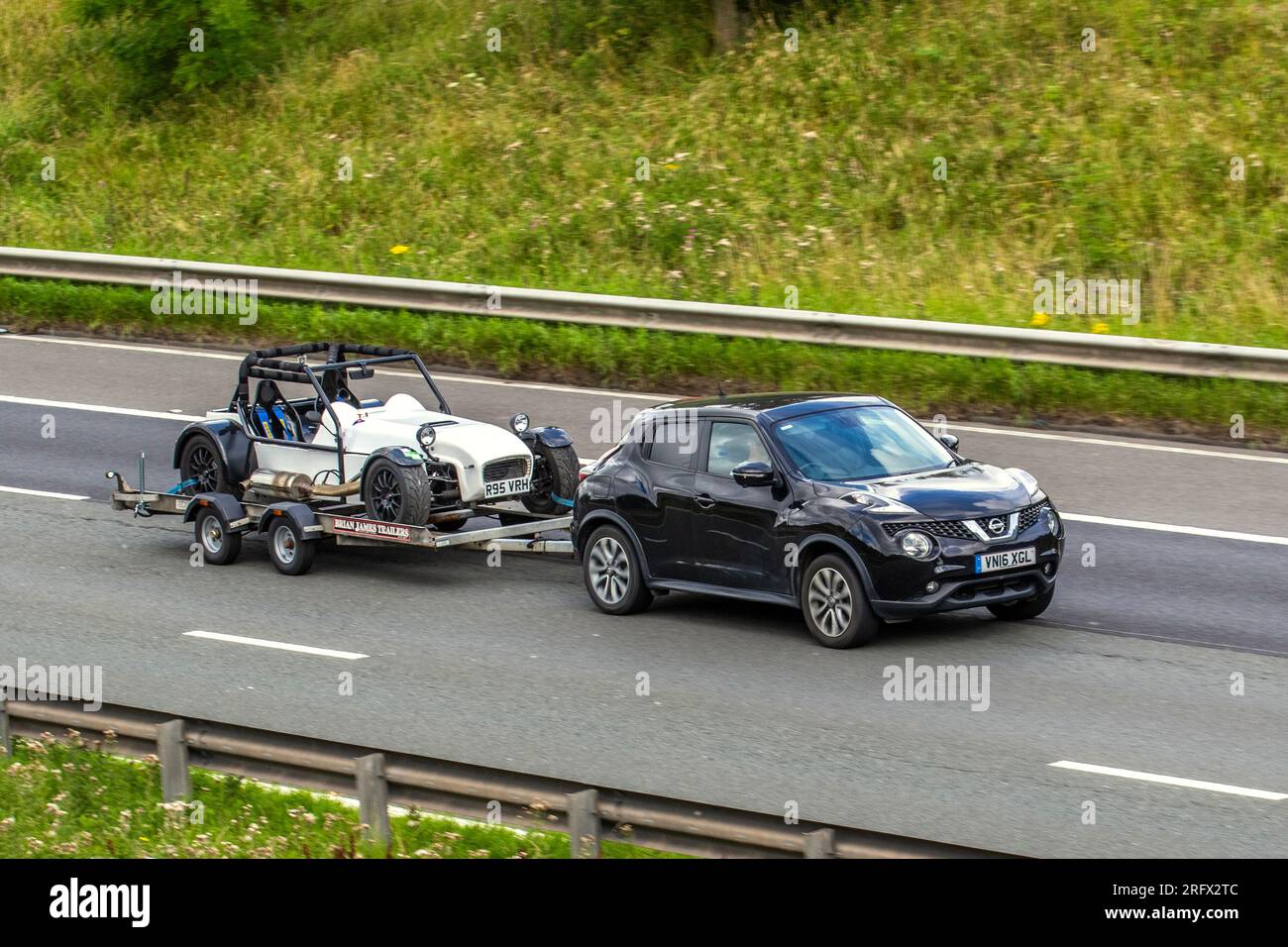 2015 GKD Legend voiture de sport légère performance essence 2793cc sur remorque Brian James remorquée par 2016 Nissan juke Tekna DCI ; voyageant sur l'autoroute M6 dans le Grand Manchester, Royaume-Uni Banque D'Images