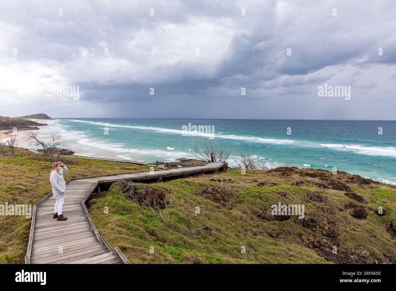 Fraser Island K'Gari Queensland, mannequin libéré femme marchant sur la promenade le jour du vent vers les piscines de champagne sur la plage de 75 mile, Australie Banque D'Images