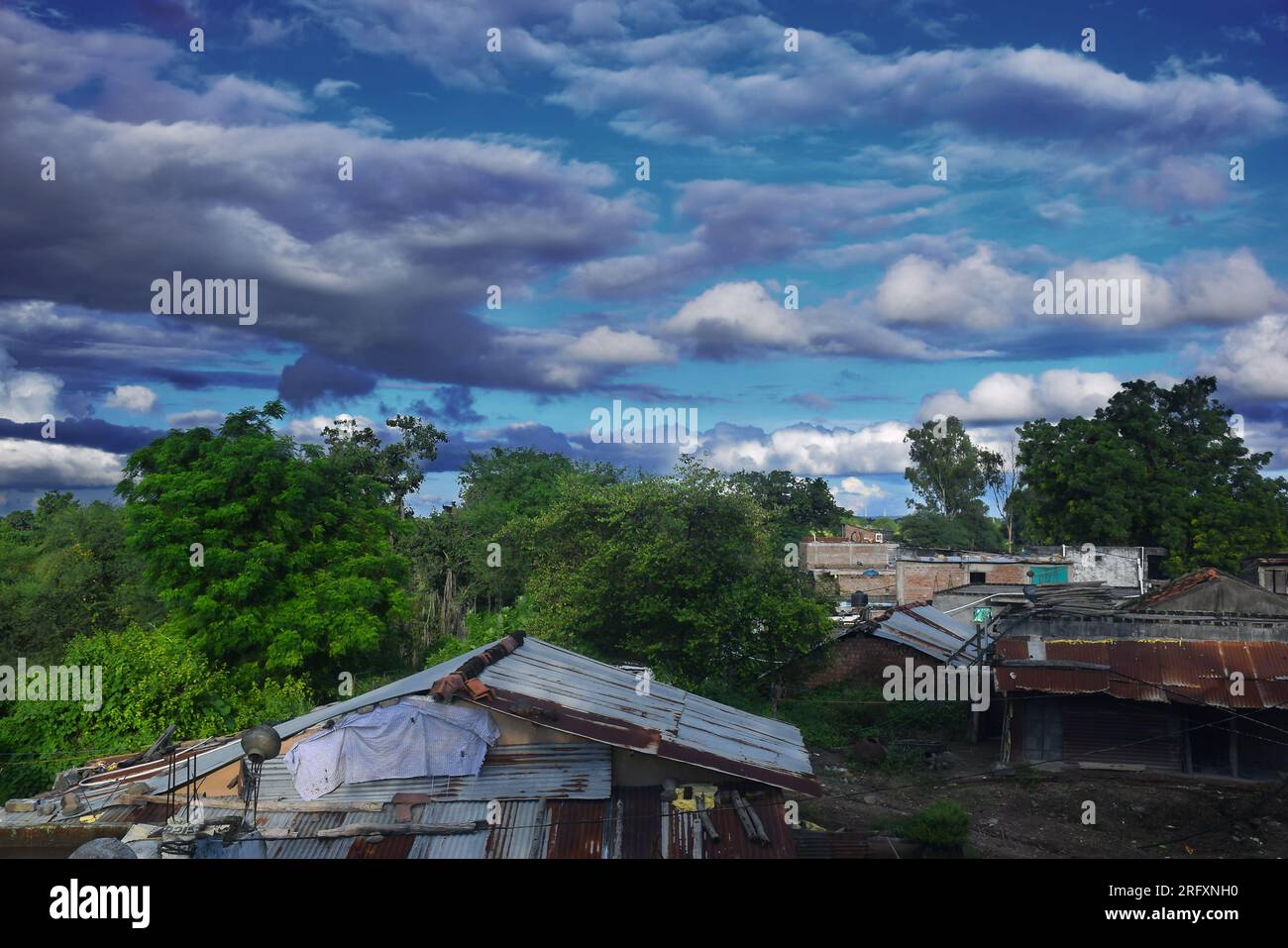 Belle vue sur le village indien en saison des pluies, ciel nuageux et verdure Banque D'Images