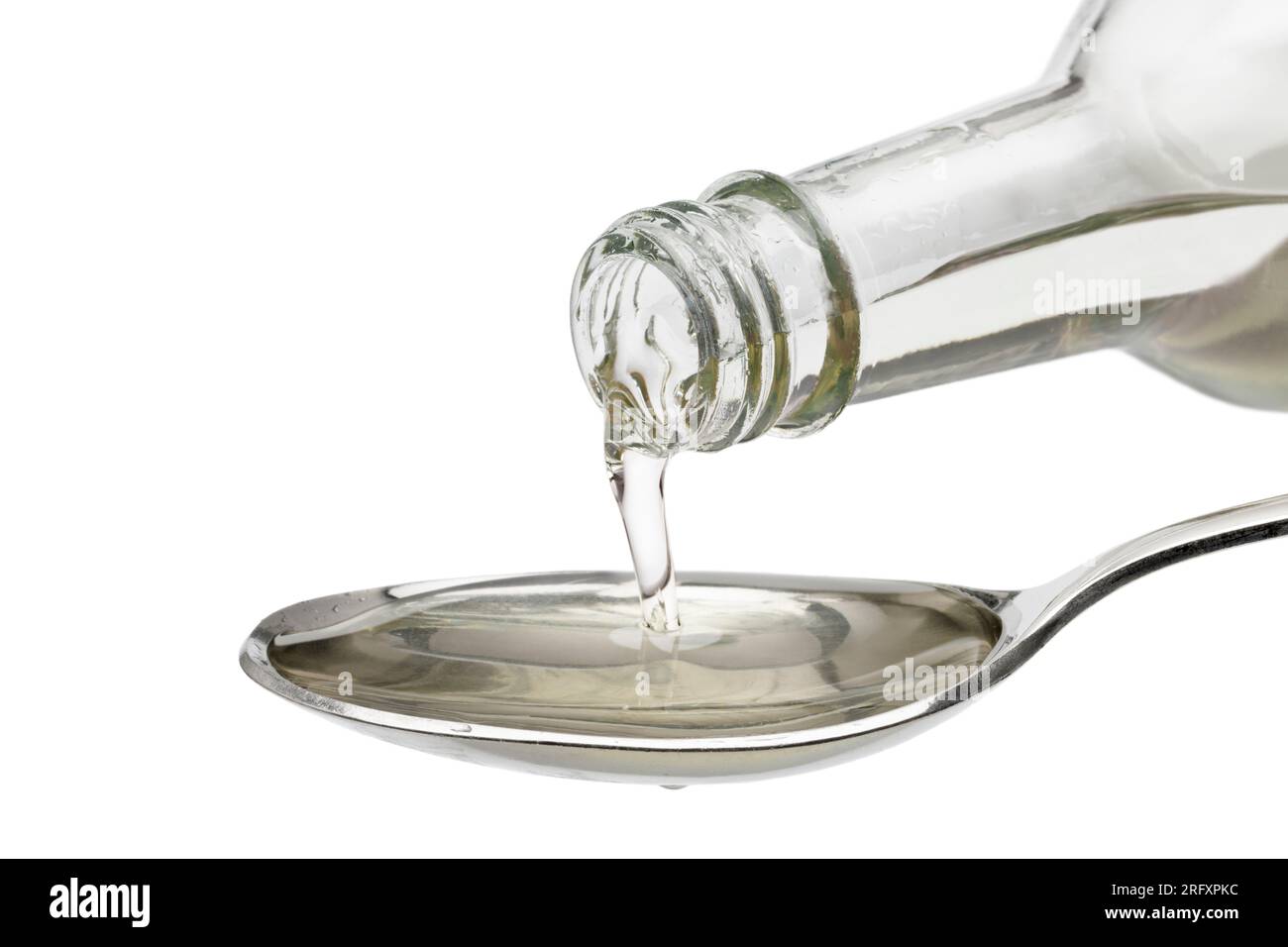 Verser Mirin japonais sur une cuillère en gros plan sur fond blanc Banque D'Images