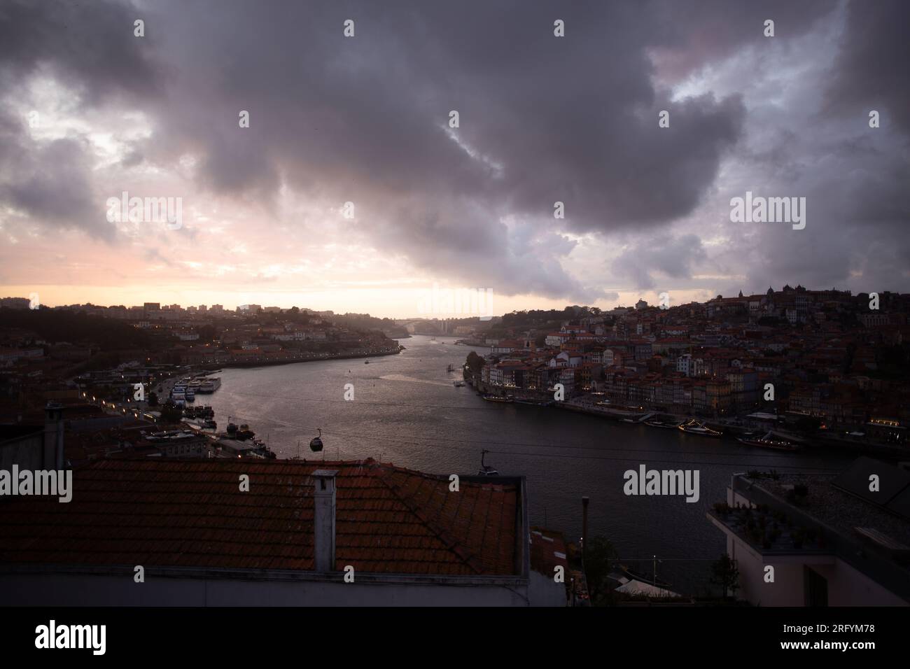 Enchantement au bord de la rivière de Porto au coucher du soleil : une toile à couper le souffle peinte avec des teintes radieuses sur le Douro, tissant la beauté urbaine et naturelle Banque D'Images