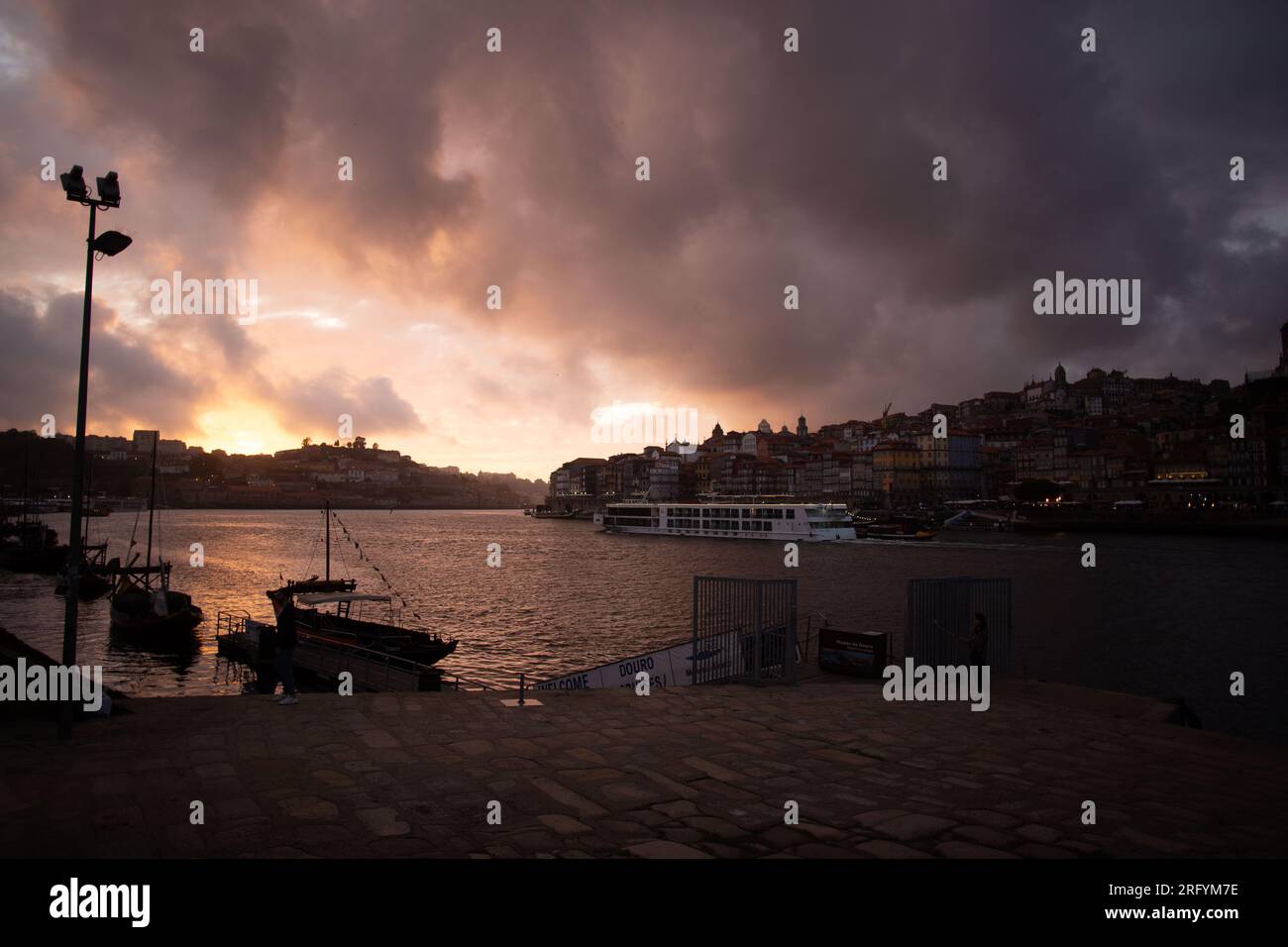 Enchantement au bord de la rivière de Porto au coucher du soleil : une toile à couper le souffle peinte avec des teintes radieuses sur le Douro, tissant la beauté urbaine et naturelle Banque D'Images