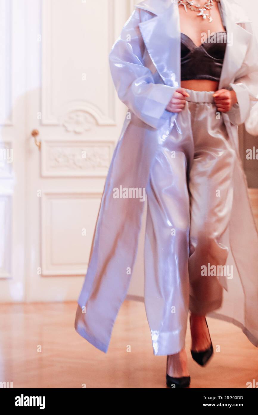 Modèle de mode féminin court en satin bleu élégant ensemble veste et pantalon chic marchant sur le défilé de mode. Banque D'Images