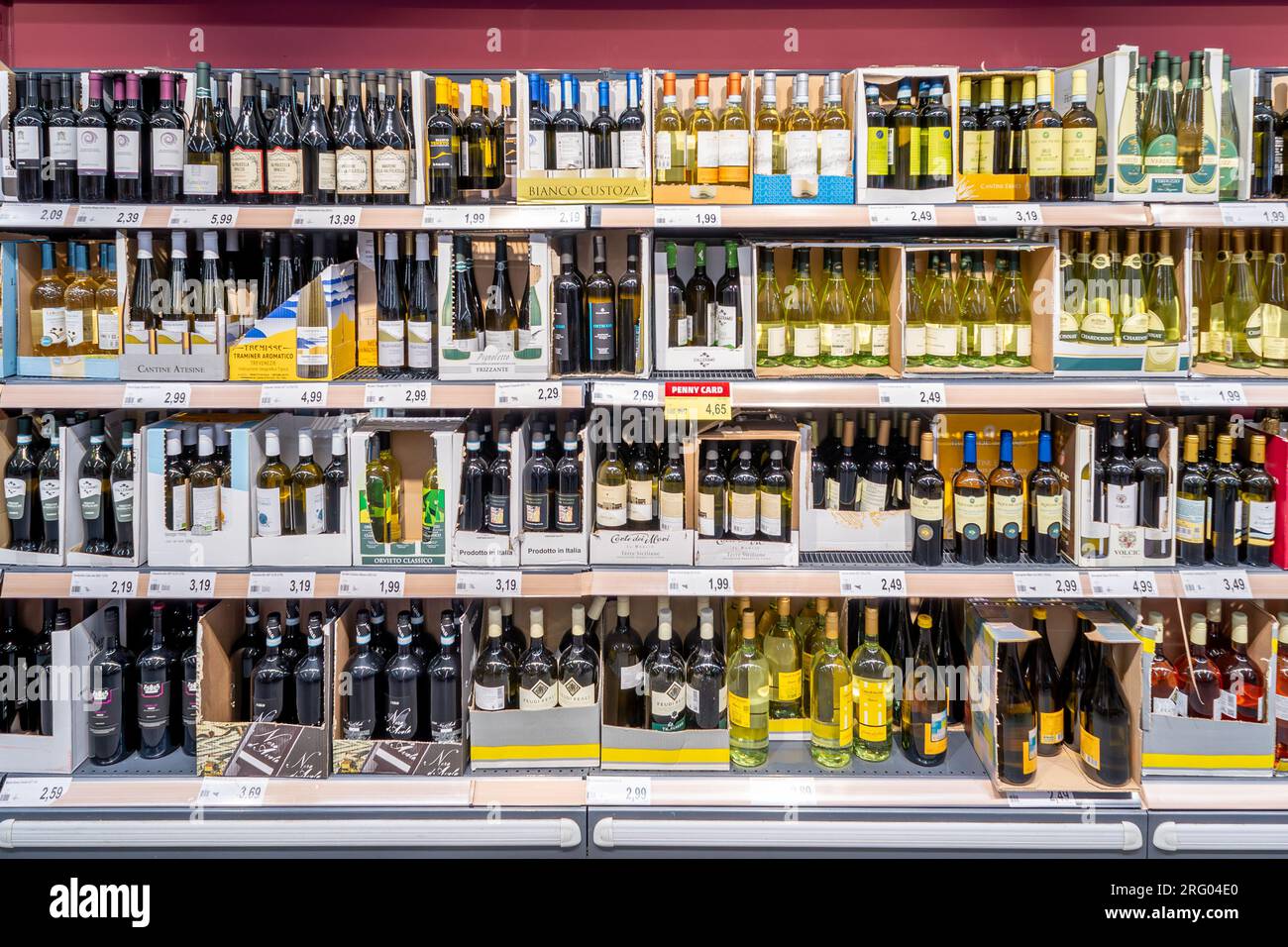 Italie - 05 août 2023 : bouteilles de vin de différents types et marques dans des boîtes en carton sur des étagères à vendre à bas prix dans un magasin discount italien Banque D'Images