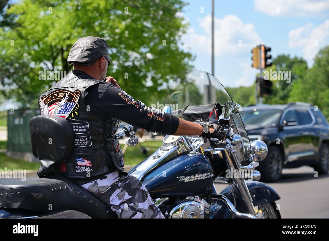 Naperville, Illinois, États-Unis. Un motard fait une pause pour un feu stop sur sa moto Harley-Davidson en voyageant à travers le comté de DuPage. Banque D'Images