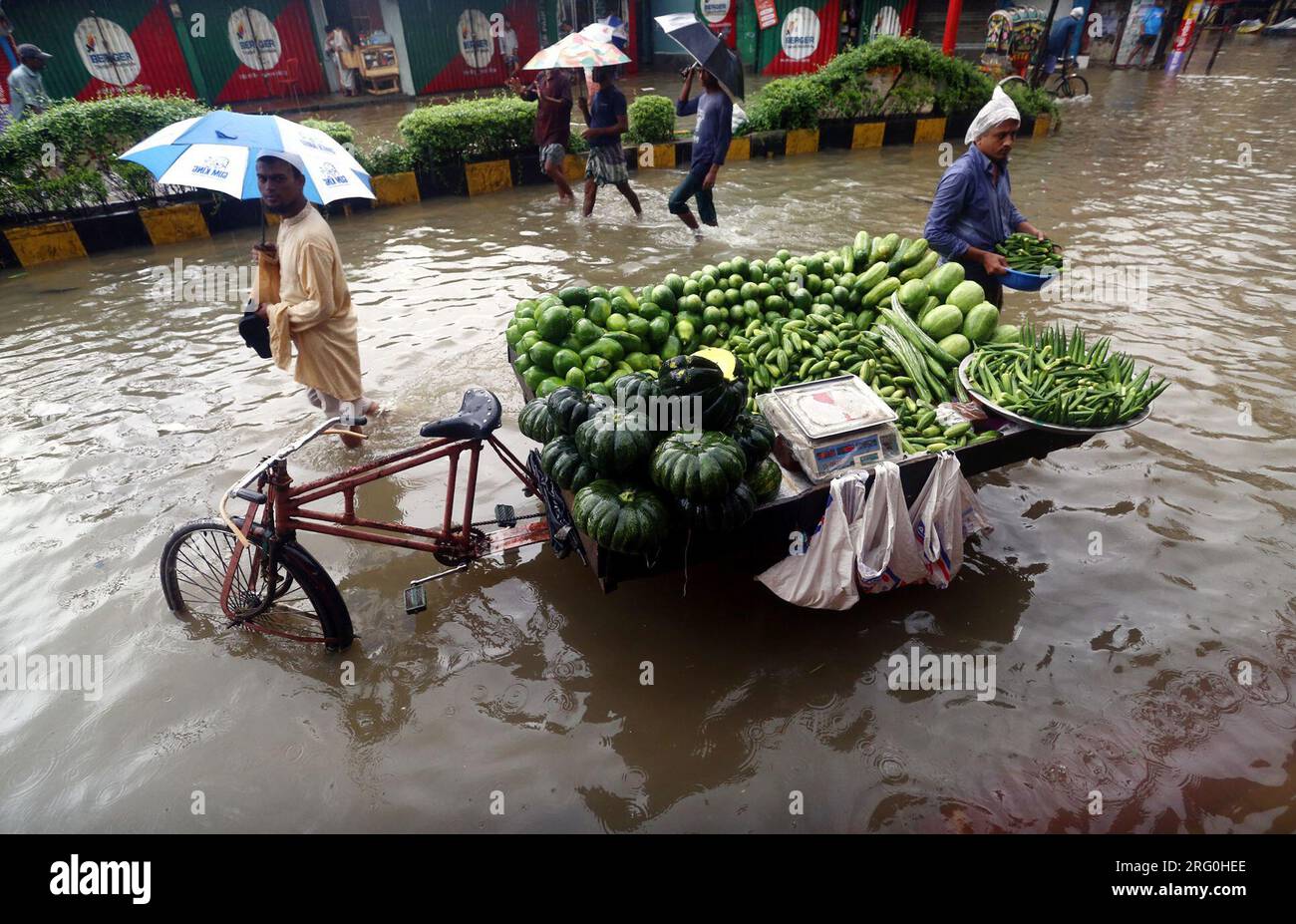 Chattogram. 7 août 2023. Un vendeur vend des légumes provenant d’une camionnette de pousse-pousse dans une rue gorgée d’eau à Chattogram, au Bangladesh, le 6 août 2023. Des jours de pluies torrentielles ont frappé la ville portuaire du Bangladesh, Chattogram, à quelque 242 km au sud-est de la capitale Dhaka, inondant les zones de faible altitude et perturbant la circulation routière. Crédit : Xinhua/Alamy Live News Banque D'Images