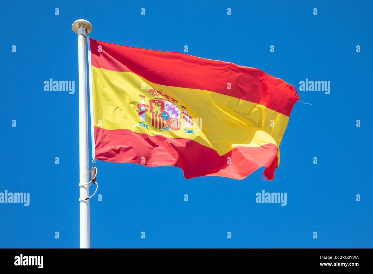 drapeau de l'espagne drapeau du pays espagnol rouge jaune sur le dessus du mât dans le vent et le ciel bleu Banque D'Images