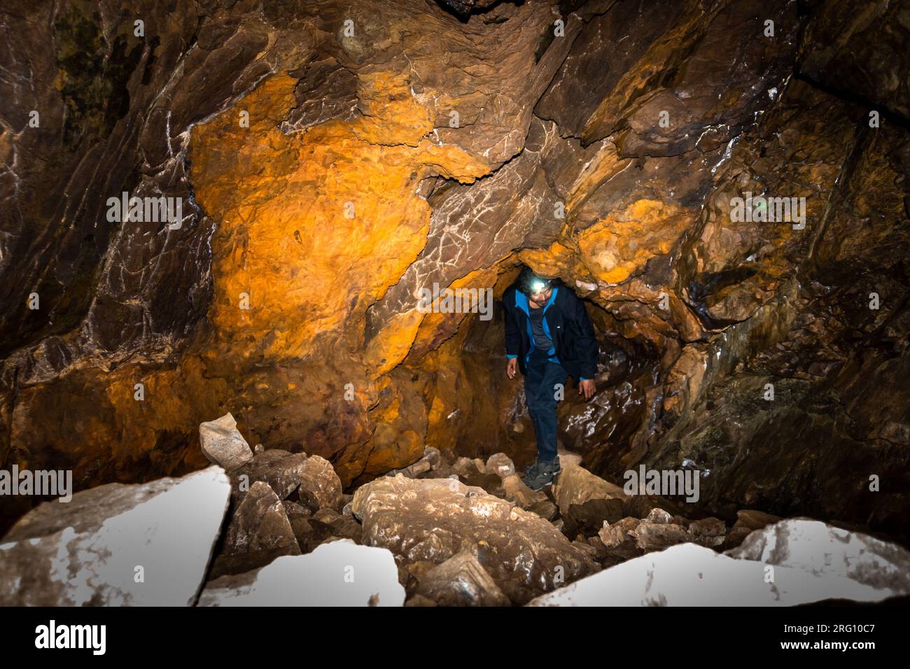 14 octobre 2022, Uttarakhand Inde. Jeune explorateur avec lampe frontale, s'aventurant profondément dans une grotte de l'Himalaya à Uttarakhand. Adresse souterraine palpitante Banque D'Images