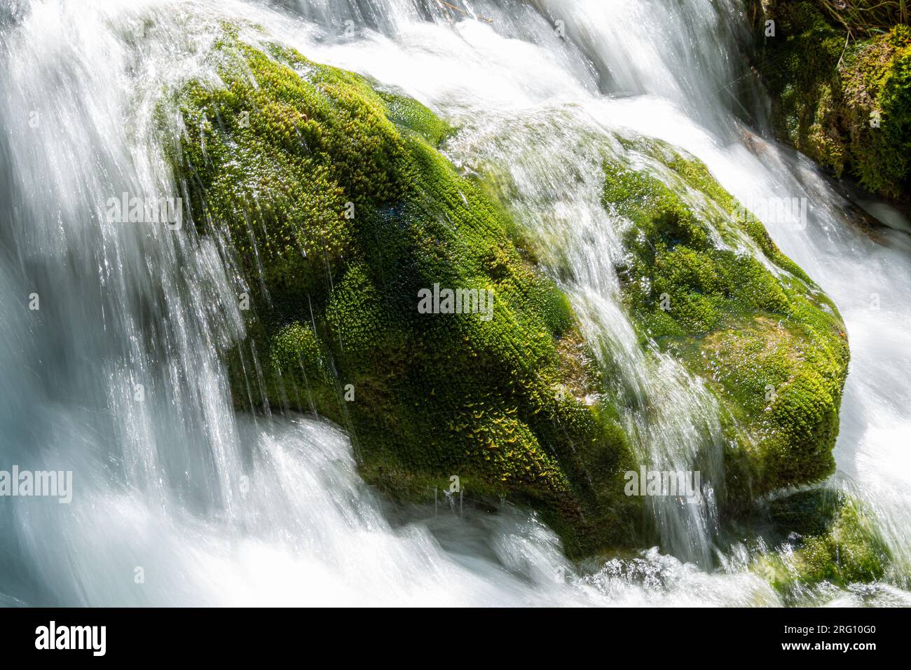De l'eau en cascade entre les rochers moussus sur l'une des nombreuses cascades du parc national des lacs de Plitvice en Croatie Banque D'Images