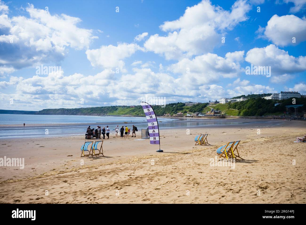 Équipe de tournage en action sur Scarborough Beach avec des nuages moelleux dans le ciel Banque D'Images