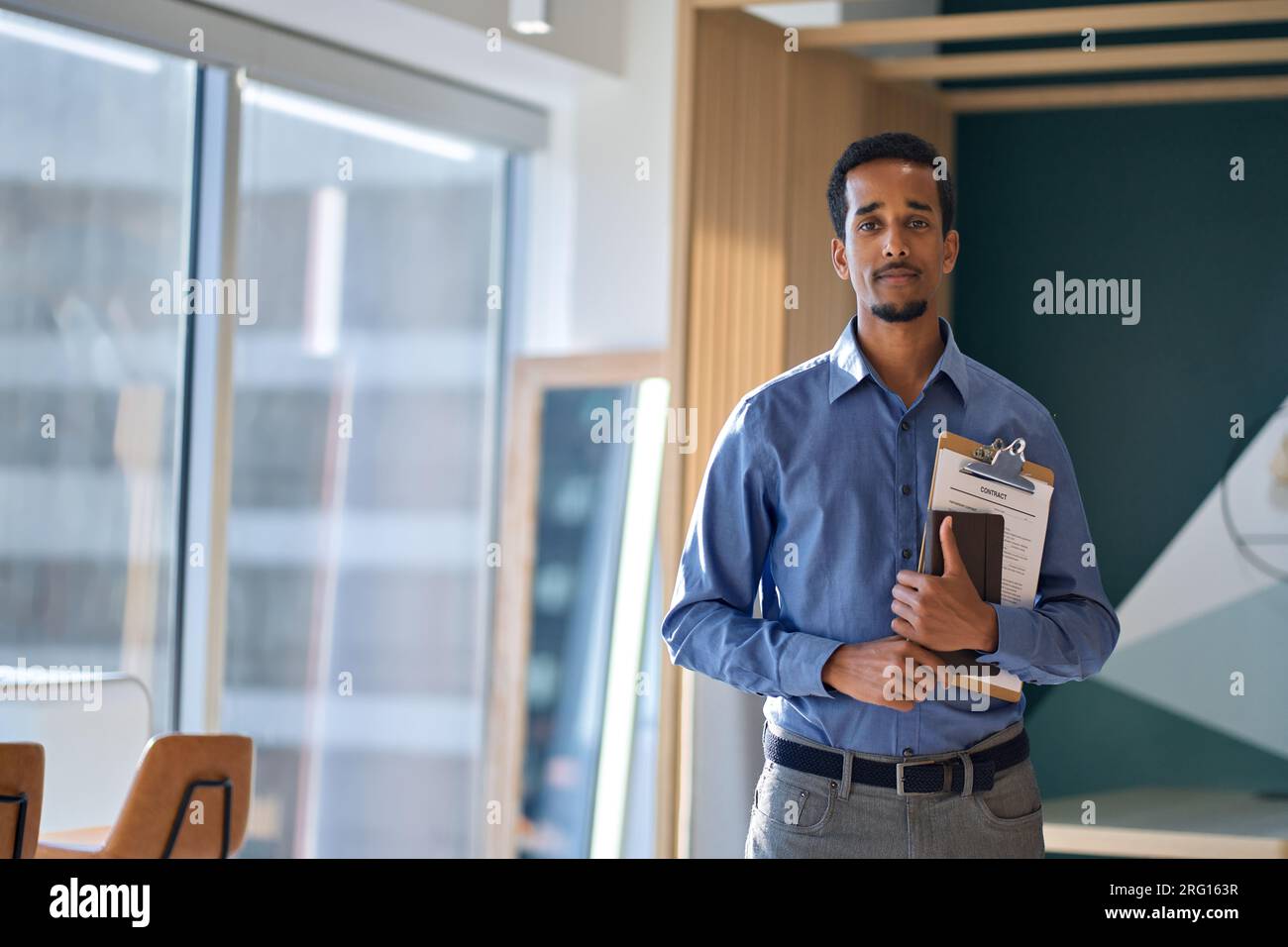 Jeune homme d'affaires afro-américain debout dans le bureau, portrait. Banque D'Images