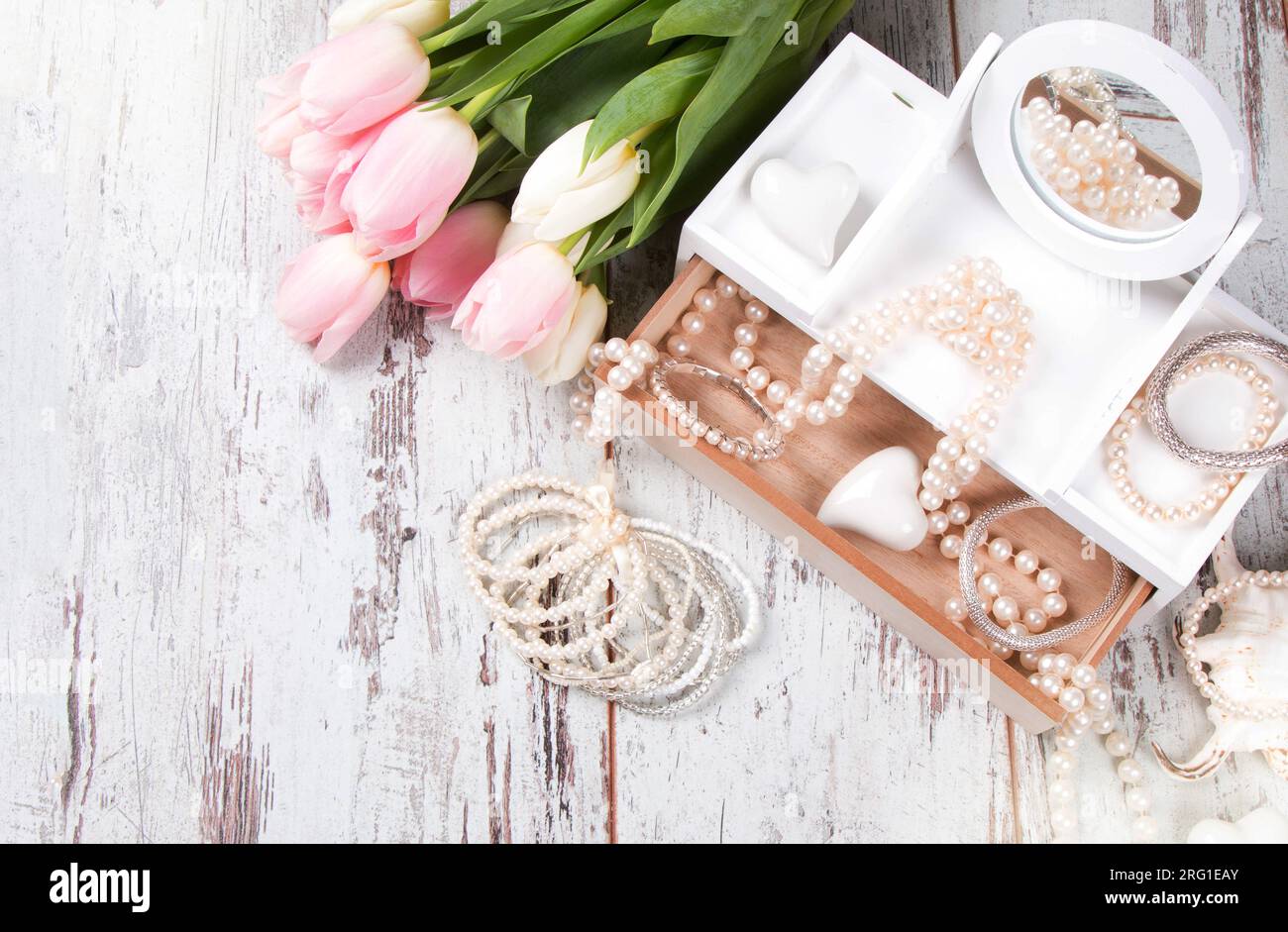 Paquet de bijoux romantique avec des perles et des fleurs sur la table. espace de copie de vue de dessus. Banque D'Images