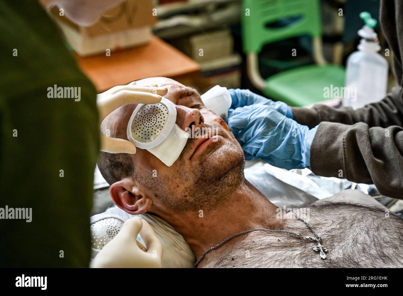 ZAPORIZHZHIA REGION, UKRAINE - le 27 JUILLET 2023 - Un militaire souffrant d'une blessure à l'oeil reçoit les premiers soins à un point de stabilisation du service médical de o Banque D'Images