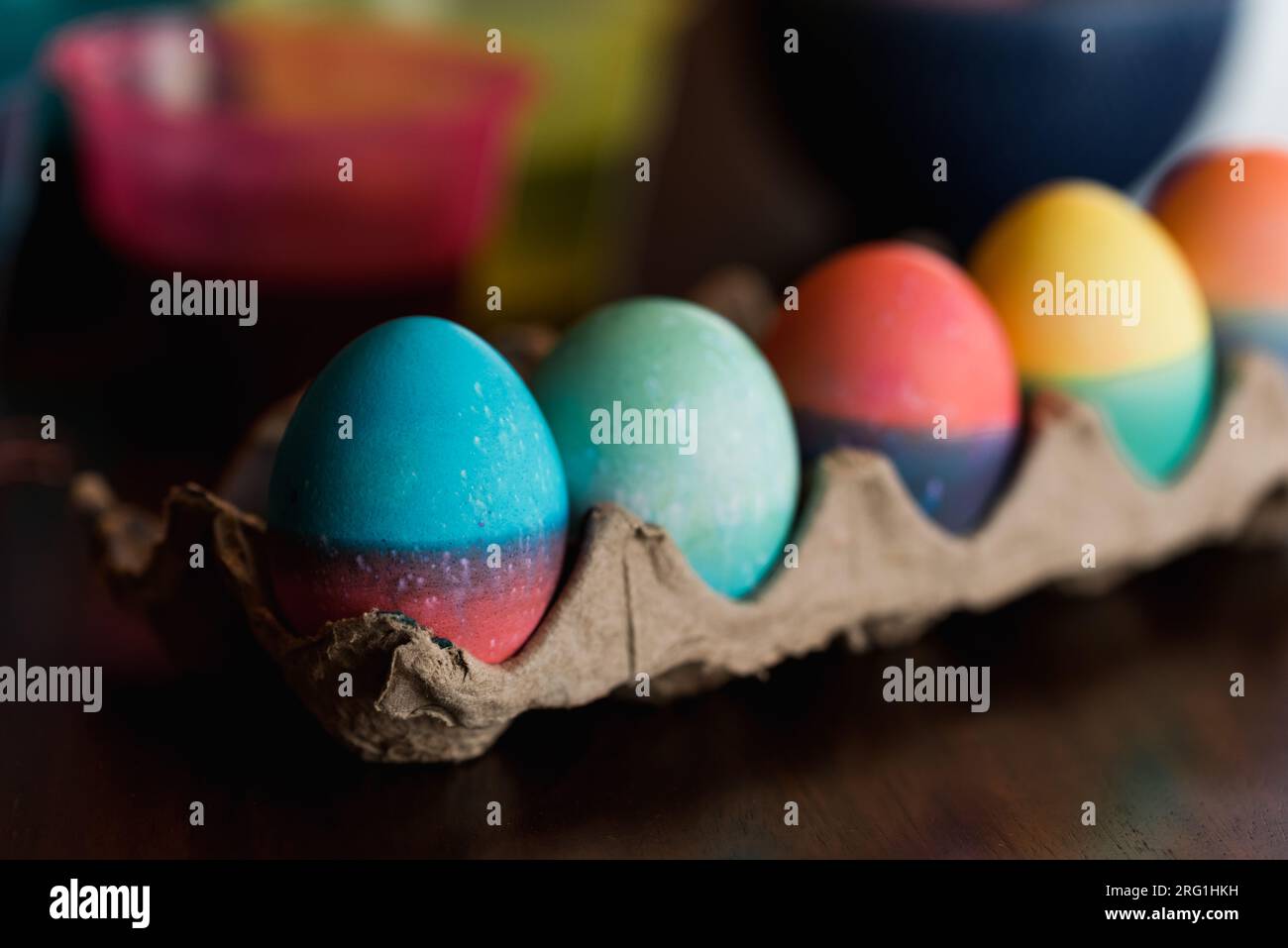 Rangée d'œufs de Pâques colorés dans un carton sur une table. Banque D'Images