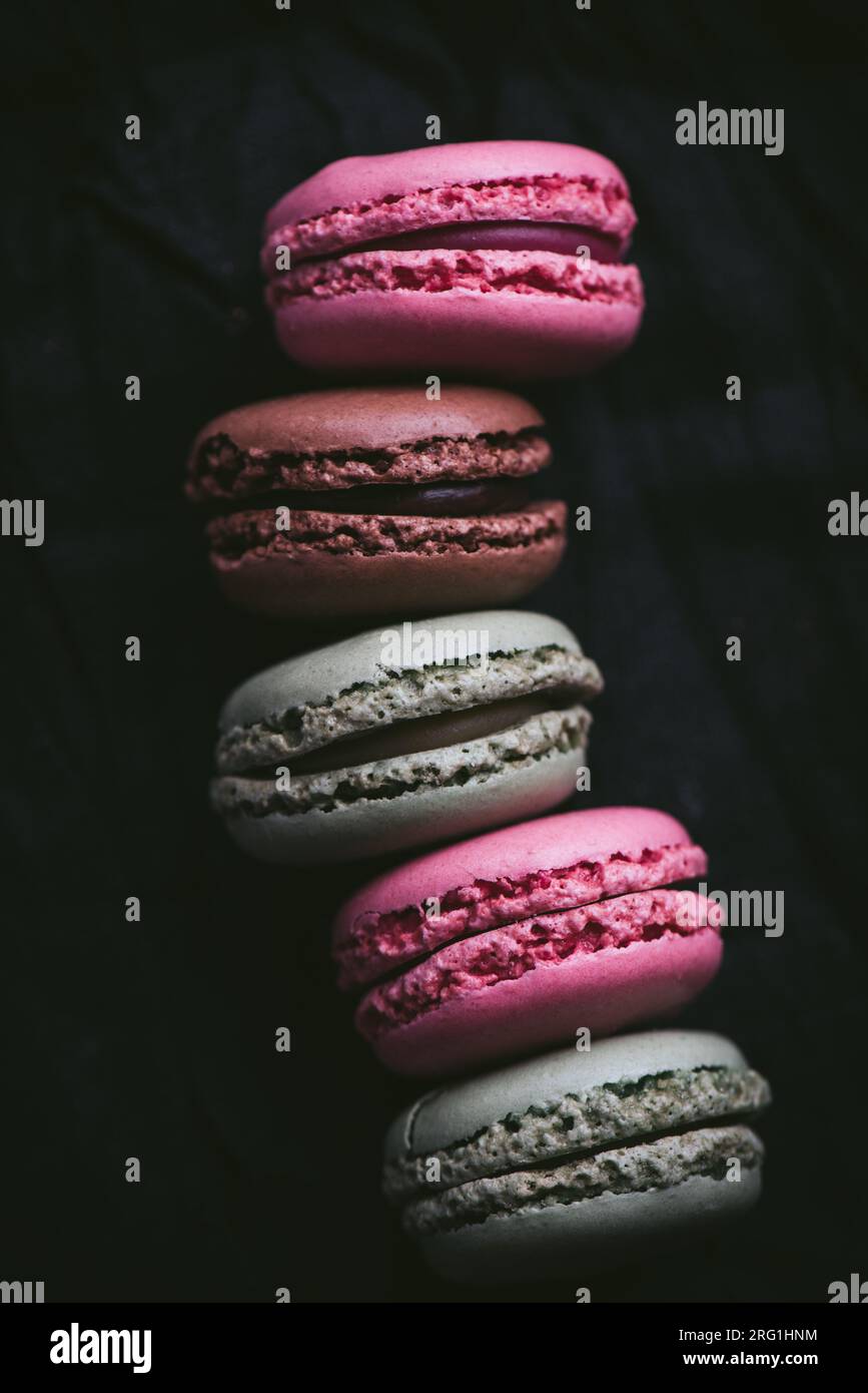 Macarons sur fond sombre, macarons de biscuits français colorés. Macarons de suite. Vue de dessus. Gros plan. Photo de haute qualité. Banque D'Images